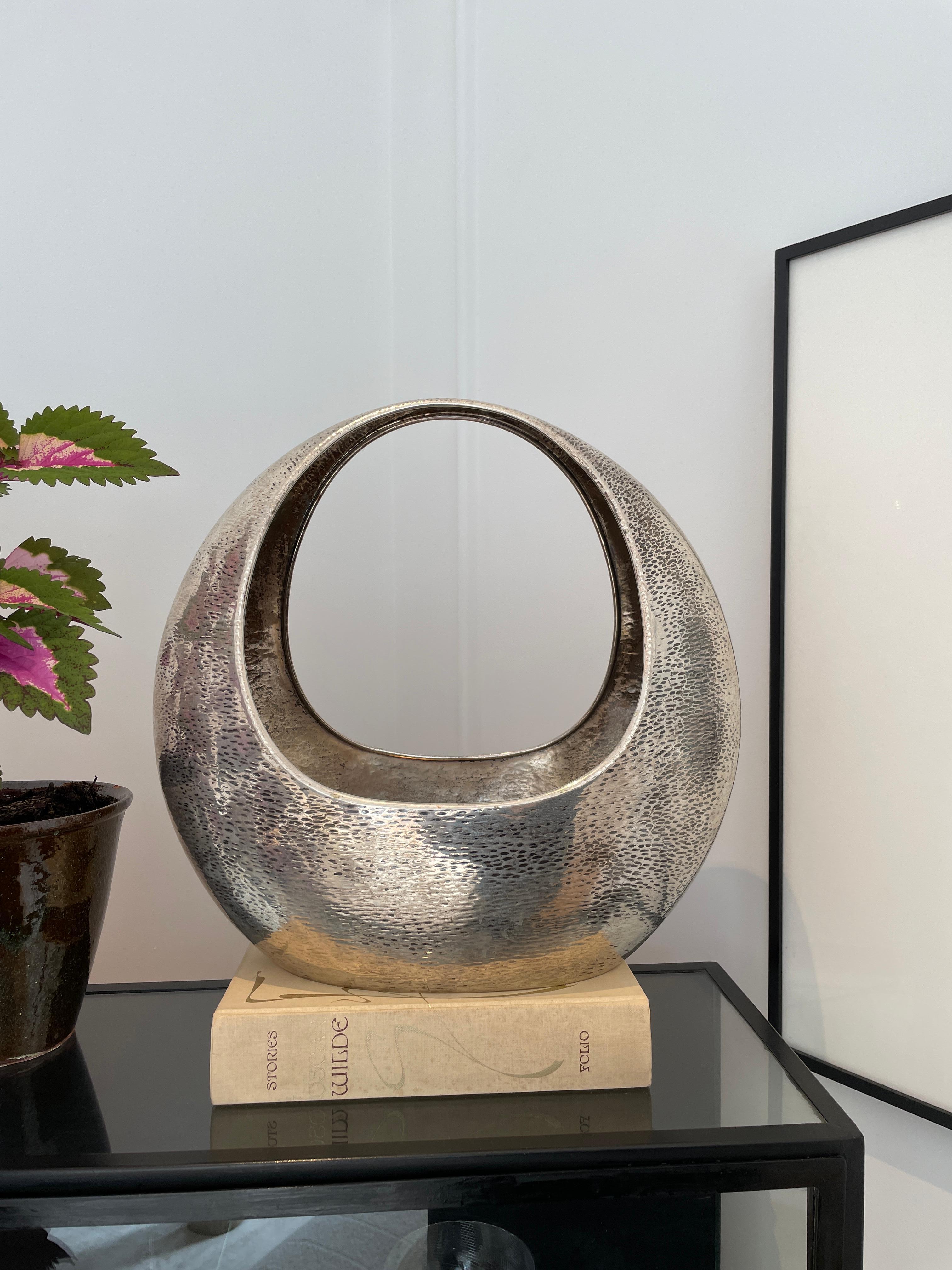 Altezza: 40 cm
Larghezza: 37 cm
Profondità: 19 cm

Designer: Nino Ferrari
Data: anni '70
Materiali: Argento

Descrizione: Il vaso a cesto Nino Ferrari è un pezzo unico e artistico creato dal designer italiano Nino Ferrari. Ispirato al concetto di