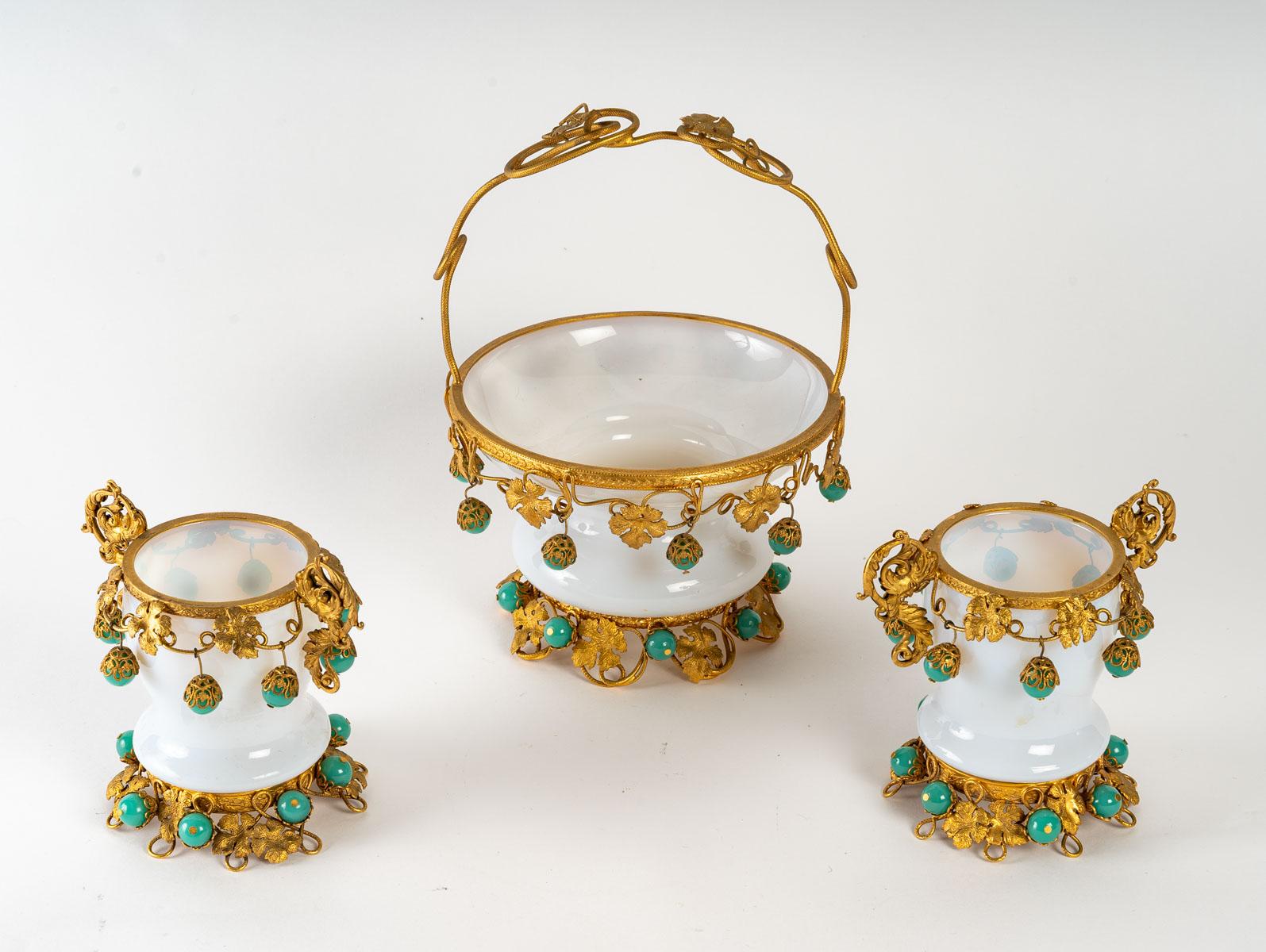 Basket and its Two Soapy White Opaline Goblets, Charles X period, gilt brass mounting and green opaline ball decoration set with gilt brass, 19th century, 1820 - 1840.
Basket - H: 21 cm, W: 16 cm, D: 15 cm
Goblet - H: 11.5 cm, W: 13 cm, D: 8 cm.