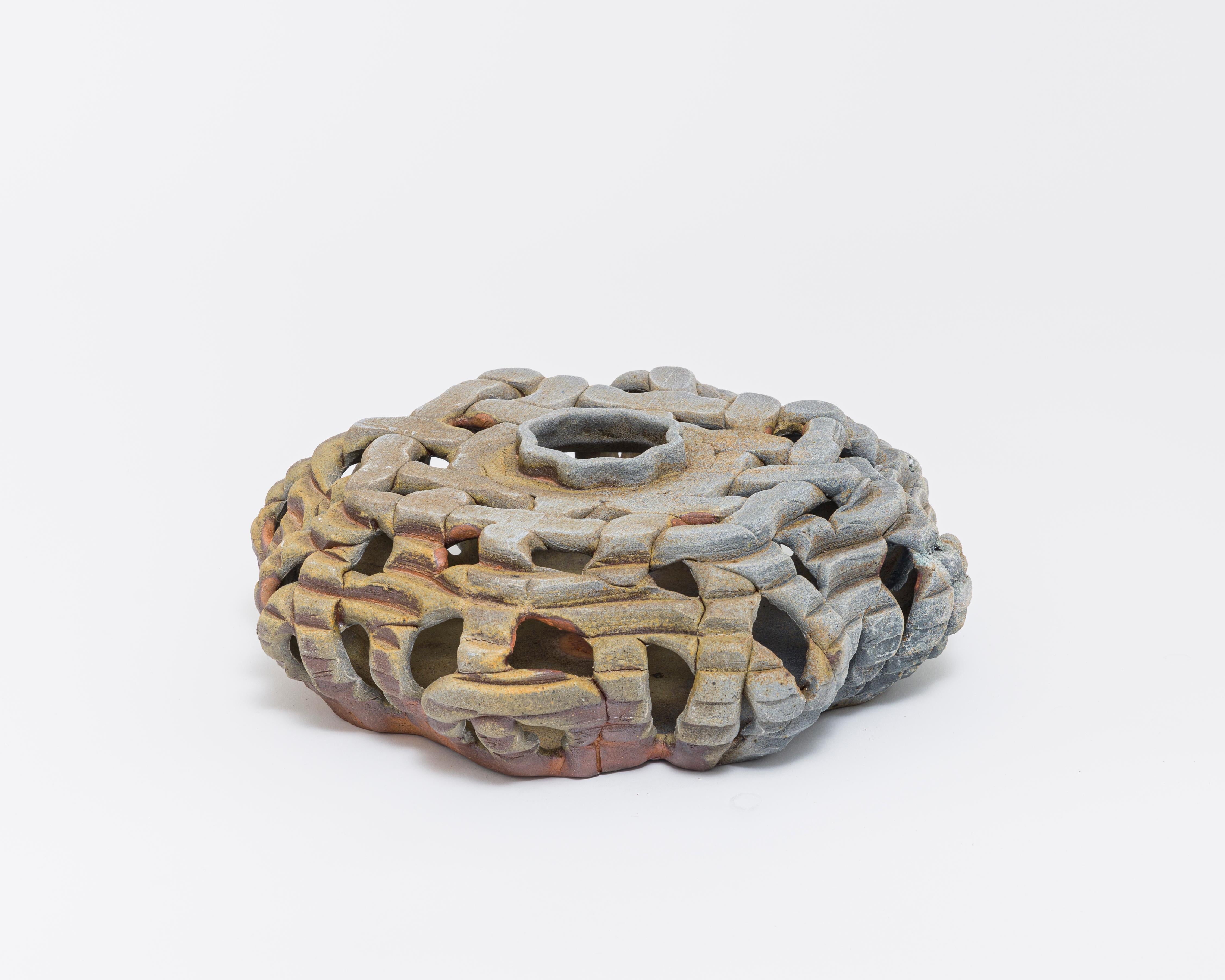 A vessel or centerpiece. Strips of clay were woven in a wooden mold to create a basket-like effect. The color comes from the natural wood-fired process.  A gorgeous piece, whose surface is full of interesting detail and variation. 

About Ellen