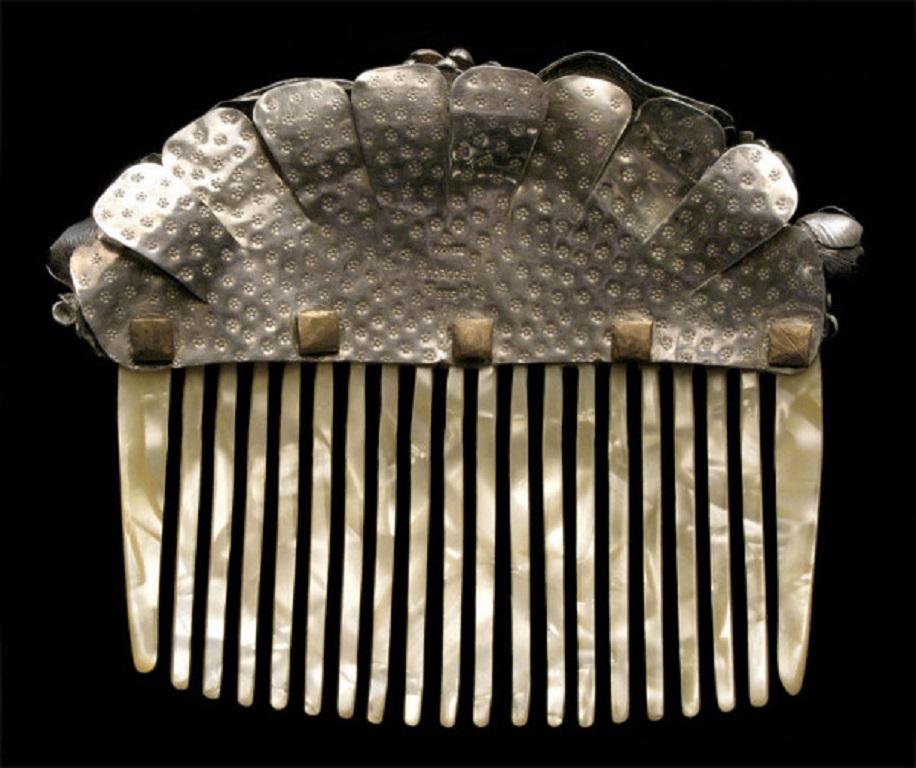 This remarkable silver comb has been made in high grade silver to allow for the fine repoussé workmanship. Made up of at least 114 handmade parts, the construction shows a very radical approach achieving the naturalism of flowers using silver in an