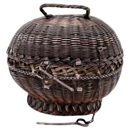 Basket-shaped silver wire box with handle and sliding closure system