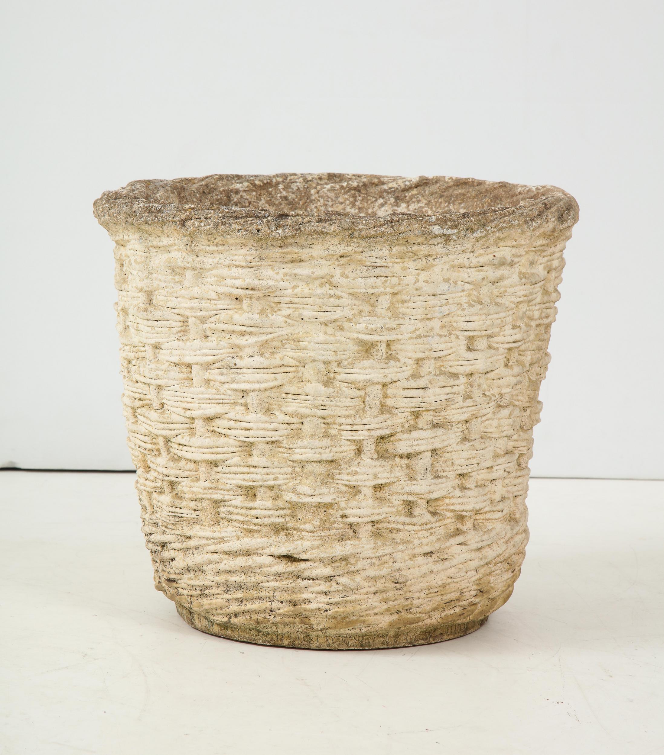 Cast stone garden planter in the style of a woven rattan basket, 20th century, French. Natural patina and wear consistent with age.