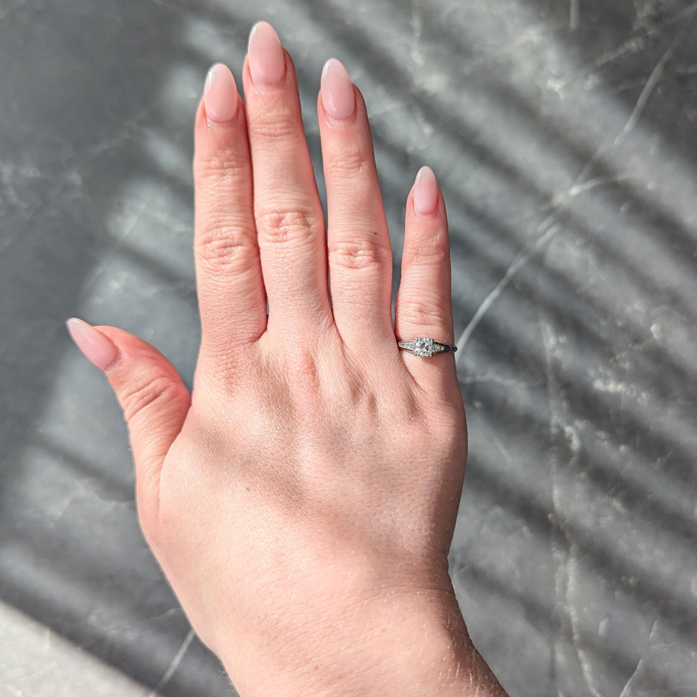 Al centro un diamante vecchio taglio europeo di circa 0,57 carati - colore H e purezza VS2.
Incastonato con rebbi tripartiti in una testa di forma quadrata e affiancato da spalle cattedrali.
Canale incastonato con diamanti a taglio singolo per un