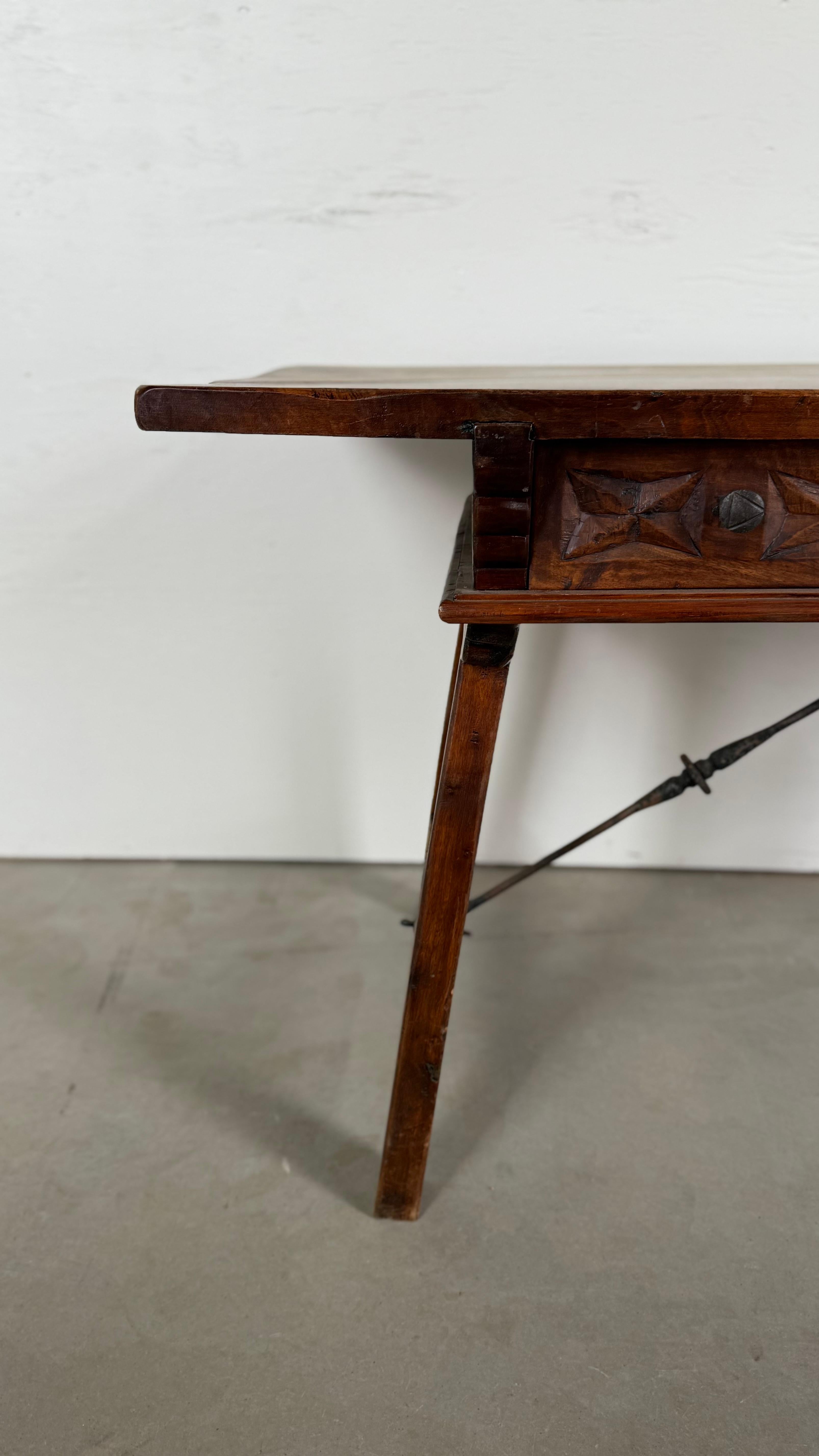 Riche en caractère et en savoir-faire, cette table à tréteaux basque du XIXe siècle est un exemple frappant de design européen rustique. Fabriquée en noyer massif patiné, la table comporte trois tiroirs sculptés à la main, chacun orné de boutons en