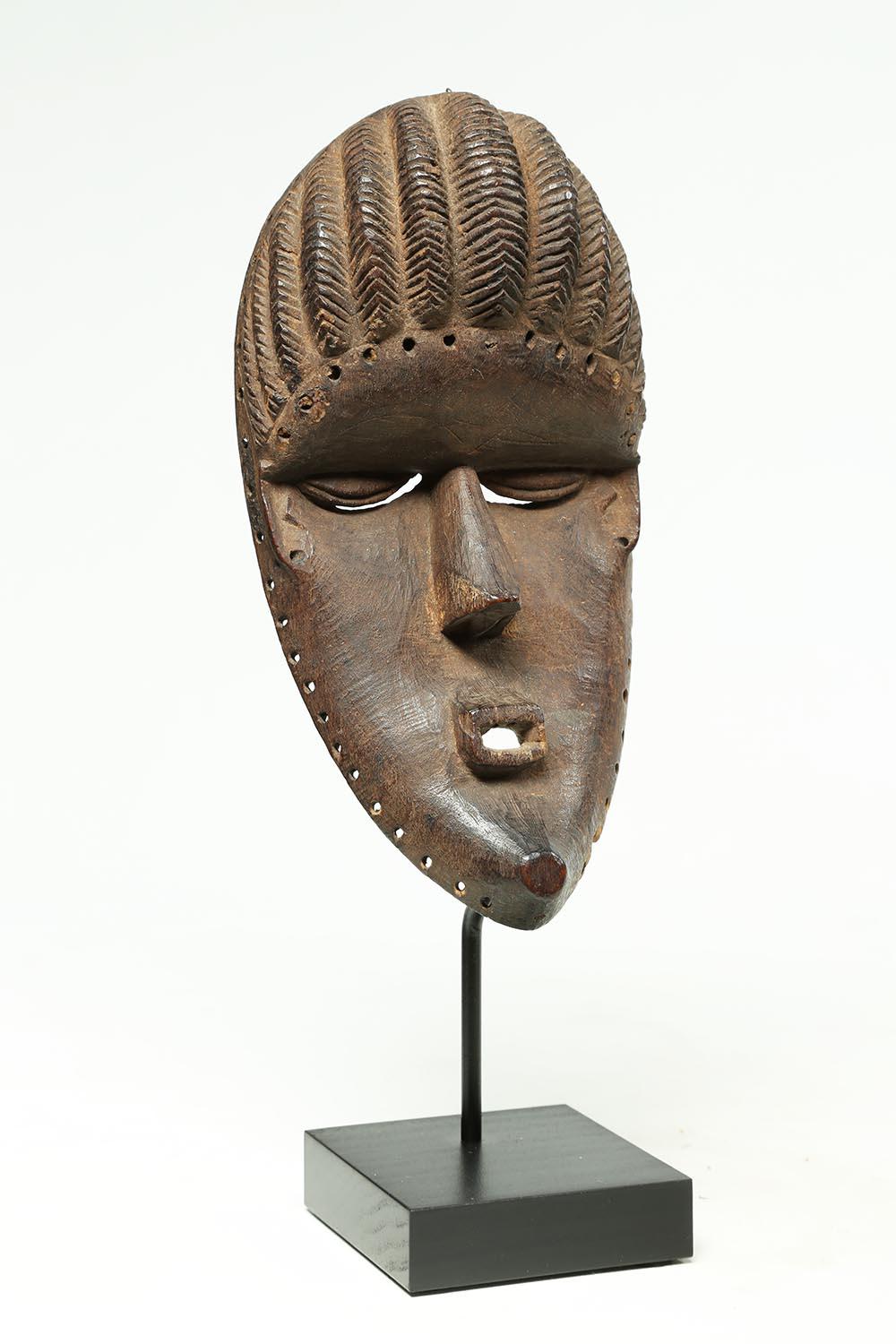 Well-used Bassa dance mask, thin and elegant wood carving with geometric features that would have been attached to a much larger dance costume. The Bassa are from Liberia, West Africa. Finely carved with good evidence of wear from use on the back.