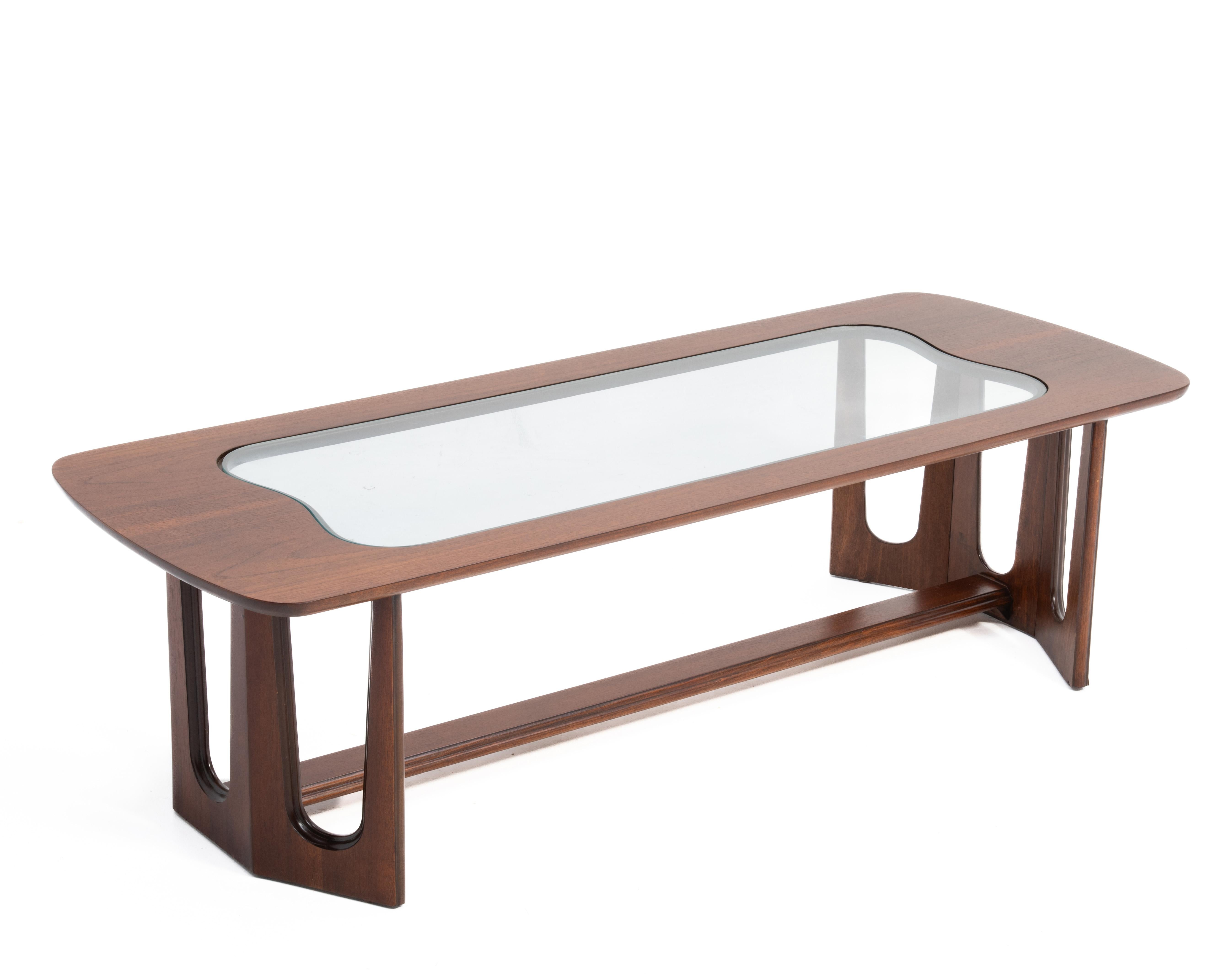 A Bassett mid century modern walnut coffee table after Adrian Pearsall with an organic and sculptural shape top, base and glass insert.
