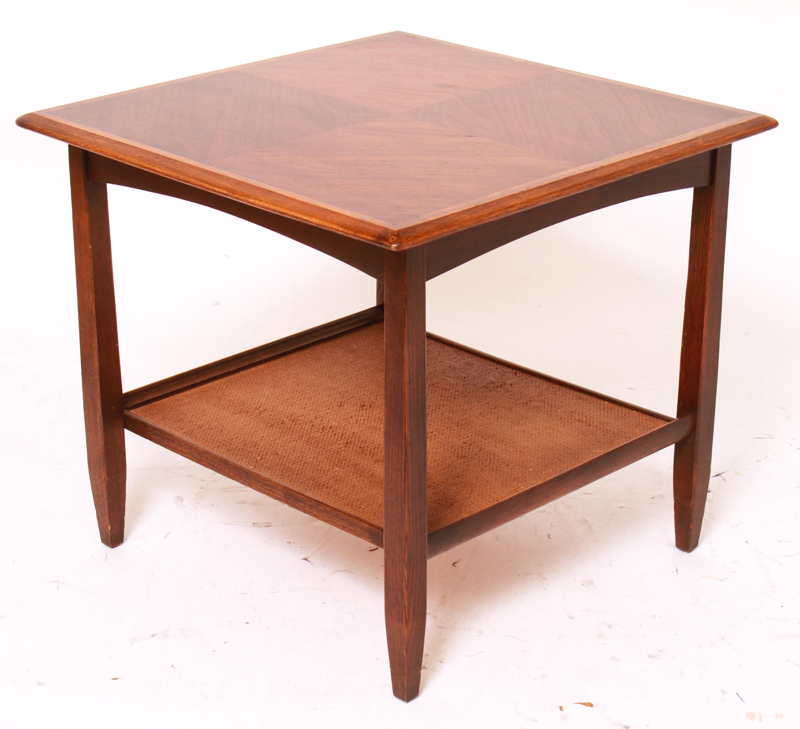 Mid-Century Modern wood end table or side table with a wood top and a rattan-lined lower shelf, made by Bassett Furniture Inc. Partial makers stamp on the bottom. The piece is in great vintage condition with age-appropriate wear.