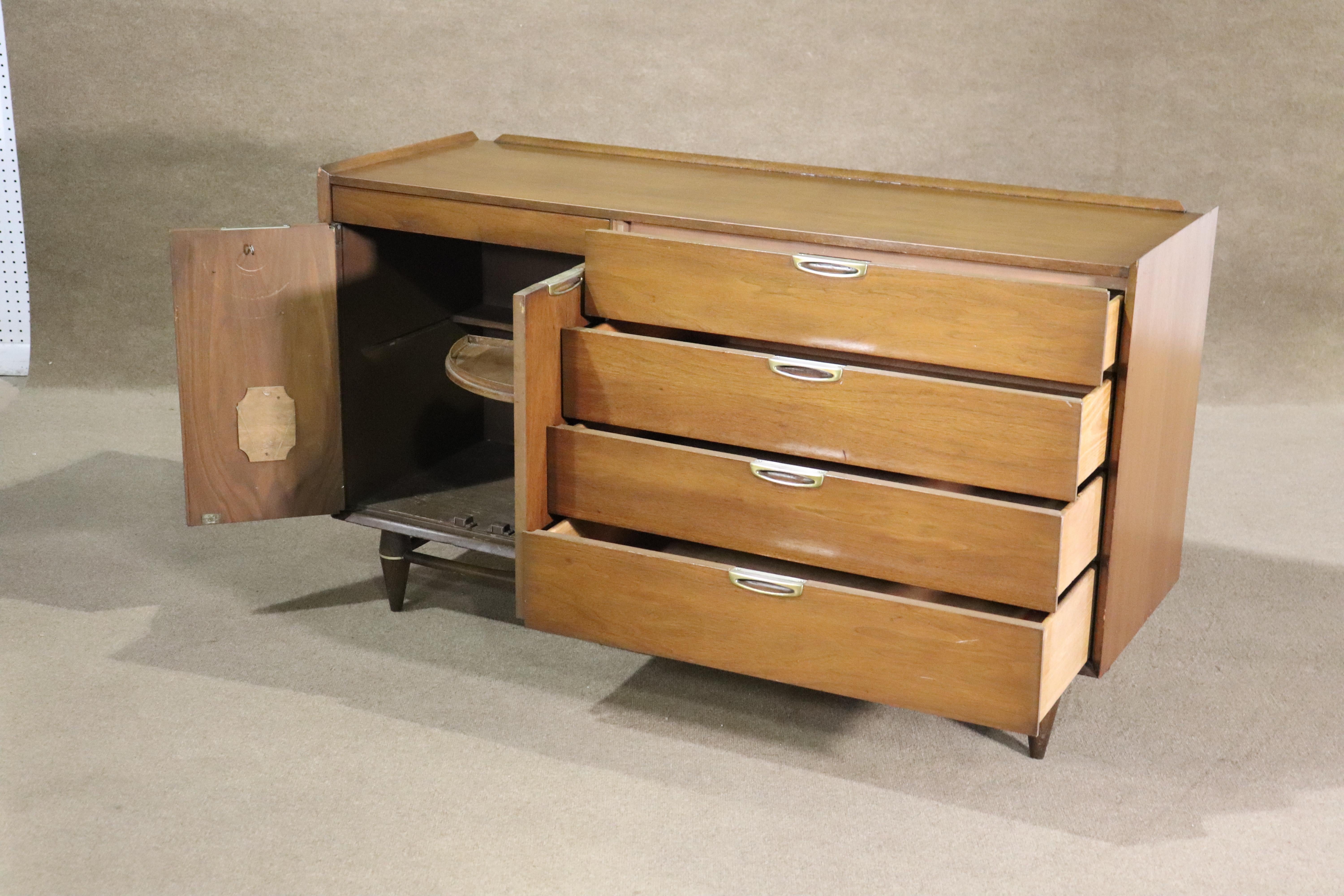 Bassett Furniture mid-century modern credenza with cabinet and drawer storage. Made for their 'Accent' series, featuring metal hardware, raised edges, and tapered legs.
Please confirm location NY or NJ