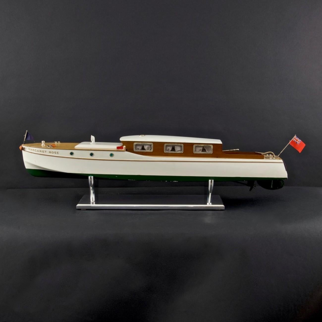 A rare 1930s clockwork model river launch/cabin cruiser ‘Margaret Rose’, so named following the birth of Princess Margaret in 1930. Made by Bassett-Lowke, with streamlined white and green painted wooden hull, light oak decking with a dark wood cabin
