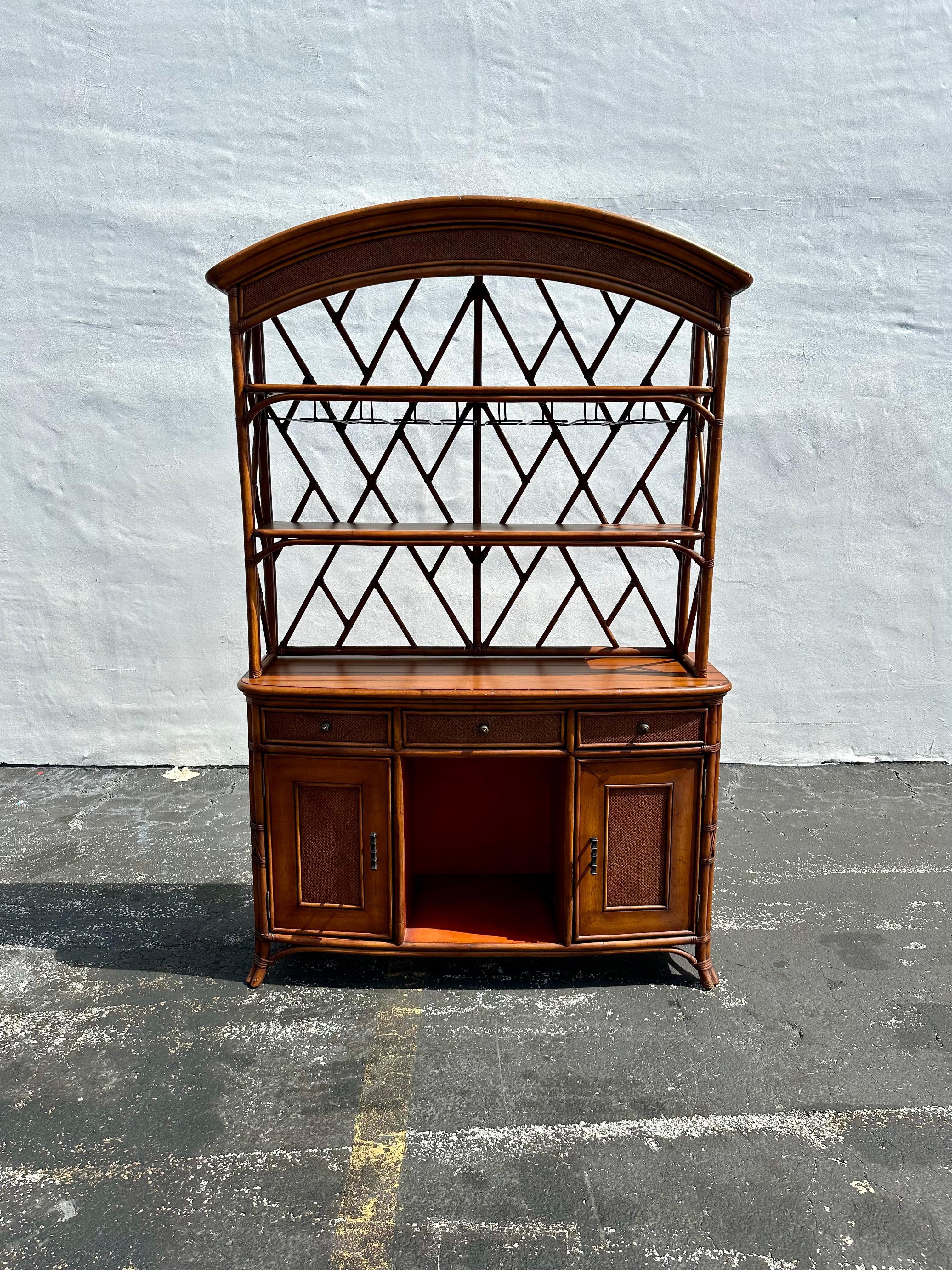Transpórtate a los elegantes y sofisticados principios de los 90 con este exquisito mueble bar/bodega de ratán y madera hecho a mano. El mueble ultra raro da un aire de cultura y refinamiento. El diseño es extraordinario en todas partes. Este
