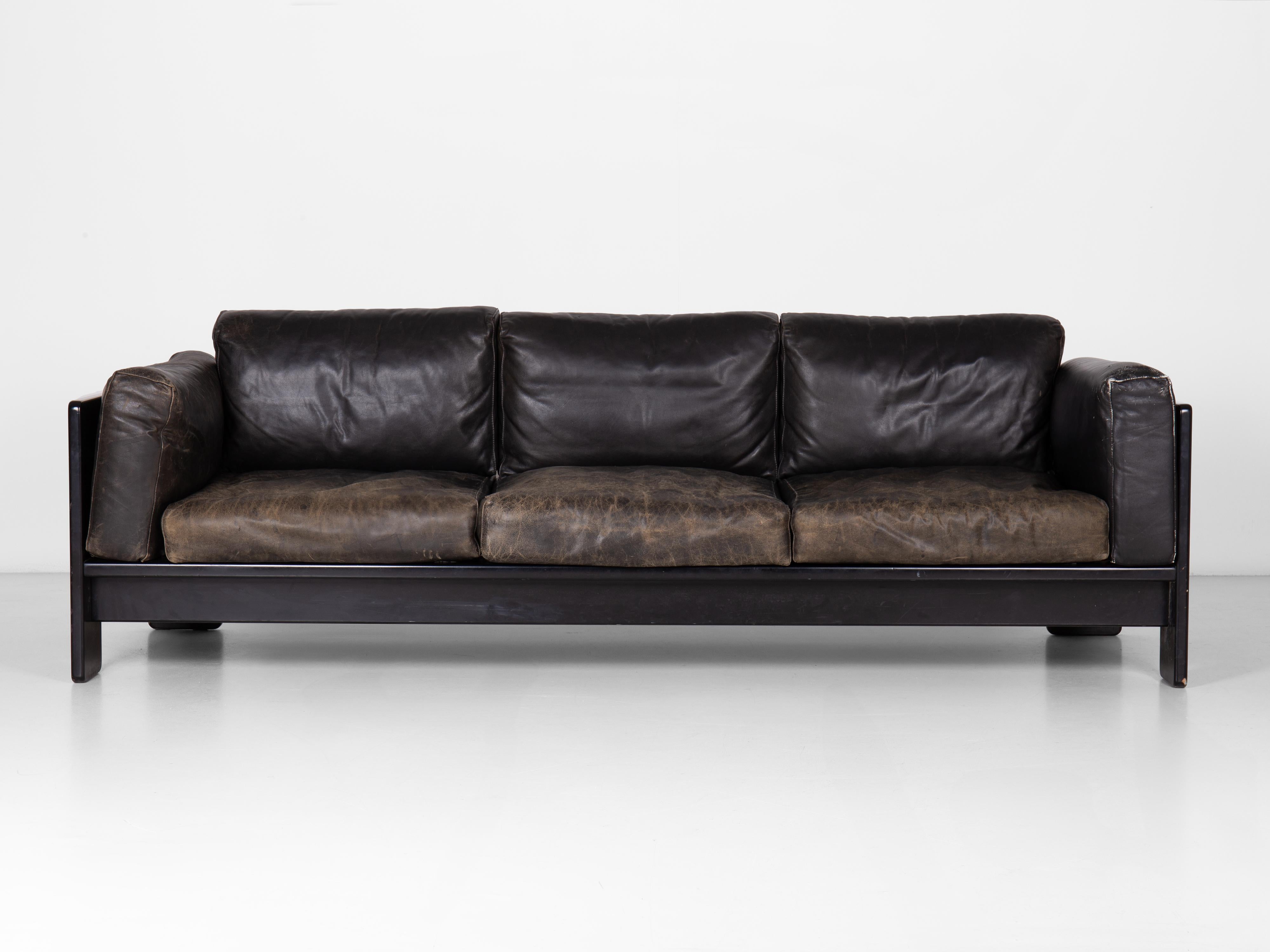 Bastiano 3 seater sofa designed by Tobia Scarpa. Supporting structure in lacquered wood. Flying cushions with polyurethane bottom and top in feather on covered steel elastic straps. Original upholstery in leather.

A simple wooden frame for a