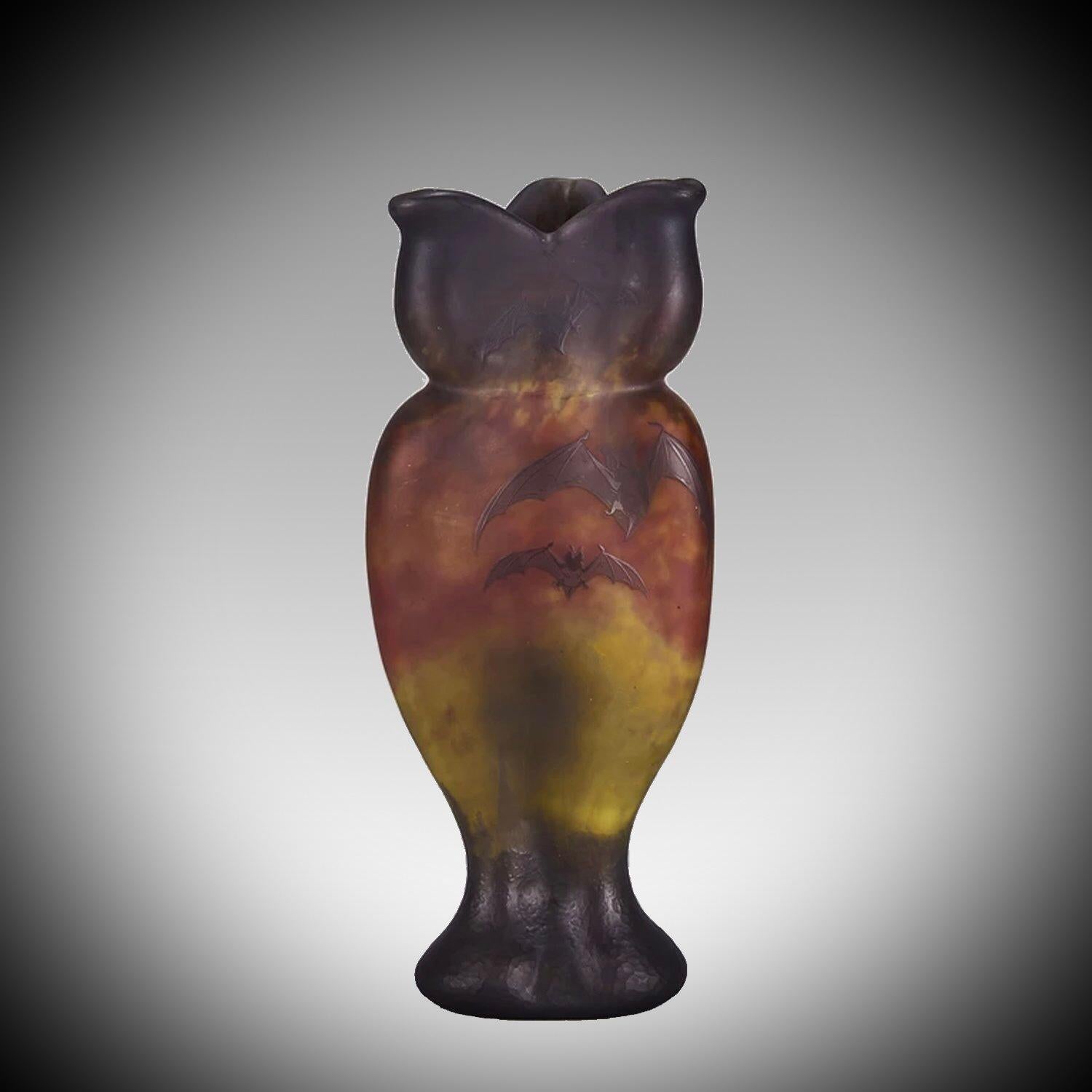 An exceptional and particularly rare Art Nouveau cameo glass vase of triform shape, the lilac layer cut and decorated with bats against a red and yellow sunset sky landscape background. Signed Daum Nancy and with the Cross of Lorraine.