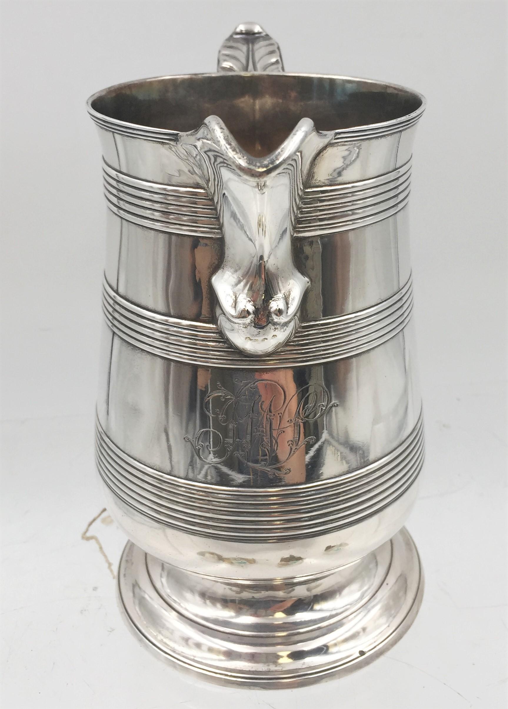 English sterling silver spouted beer jug pitcher by Peter and Ann Bateman from 1796 with applied bands and ribbon-bound reeded handle, measuring 7'' in height by 7 1/2'' from handle to spout and weighing 21.3 ozt. Bearing a JWS monogram and