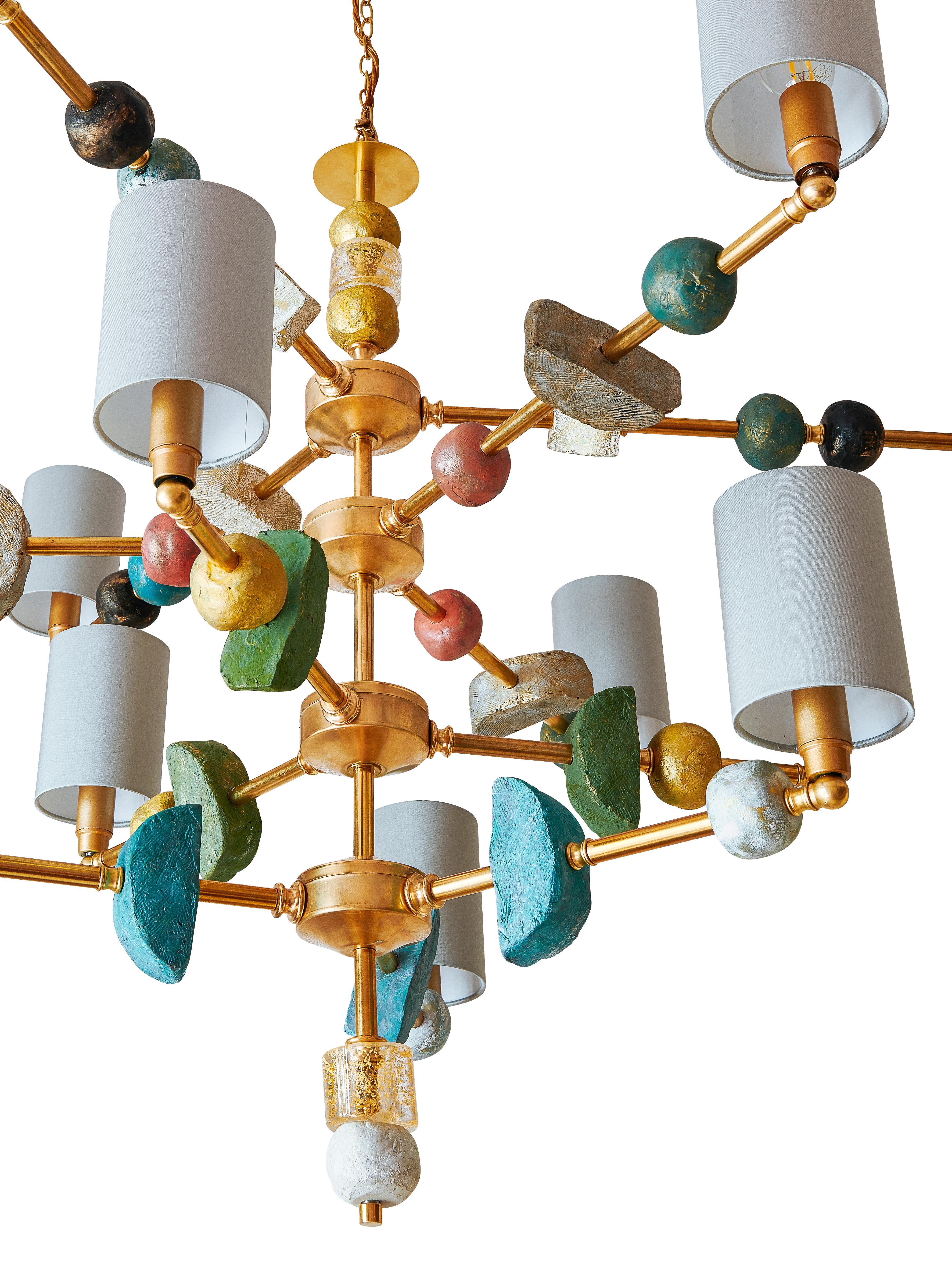 Questo lampadario contemporaneo del XXI secolo a quattro livelli e dodici bracci di Margit Wittig presenta componenti scultorei con texture organiche e sottili; tutte le forme sono fuse singolarmente e trattate con molteplici strati di patina nel