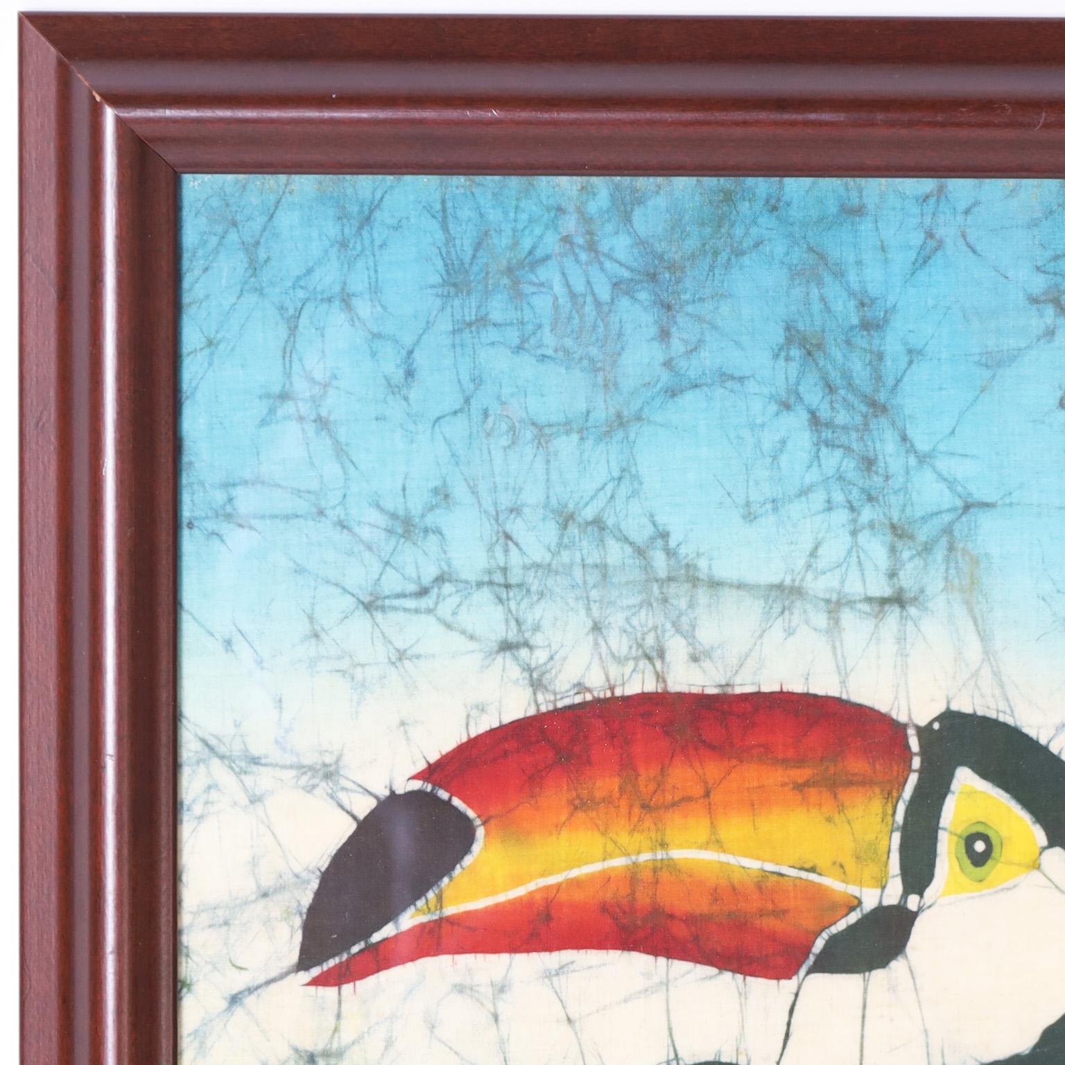 Transporting artwork of a toucan in a tree expertly executed in a batik dying technique on silk and indistinctly signed. Presented under glass in a wood frame.