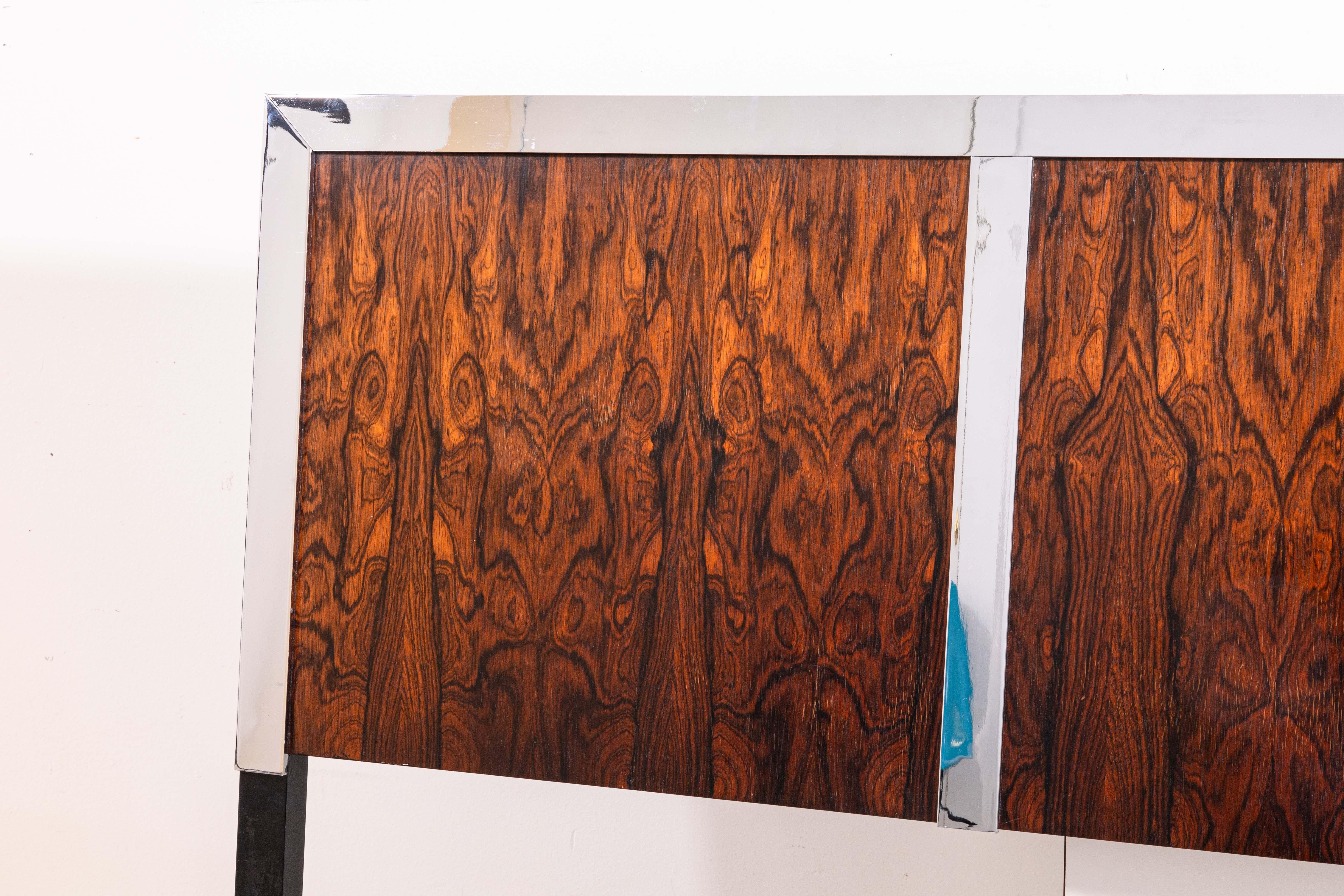 A Milo Baughman for John Stuart rosewood and chrome queen size headboard. An absolutely stunning bed frame piece. This headboard has a strong construction and design, featuring a gorgeous grain-filled set of rosewood squares, and a polished chrome