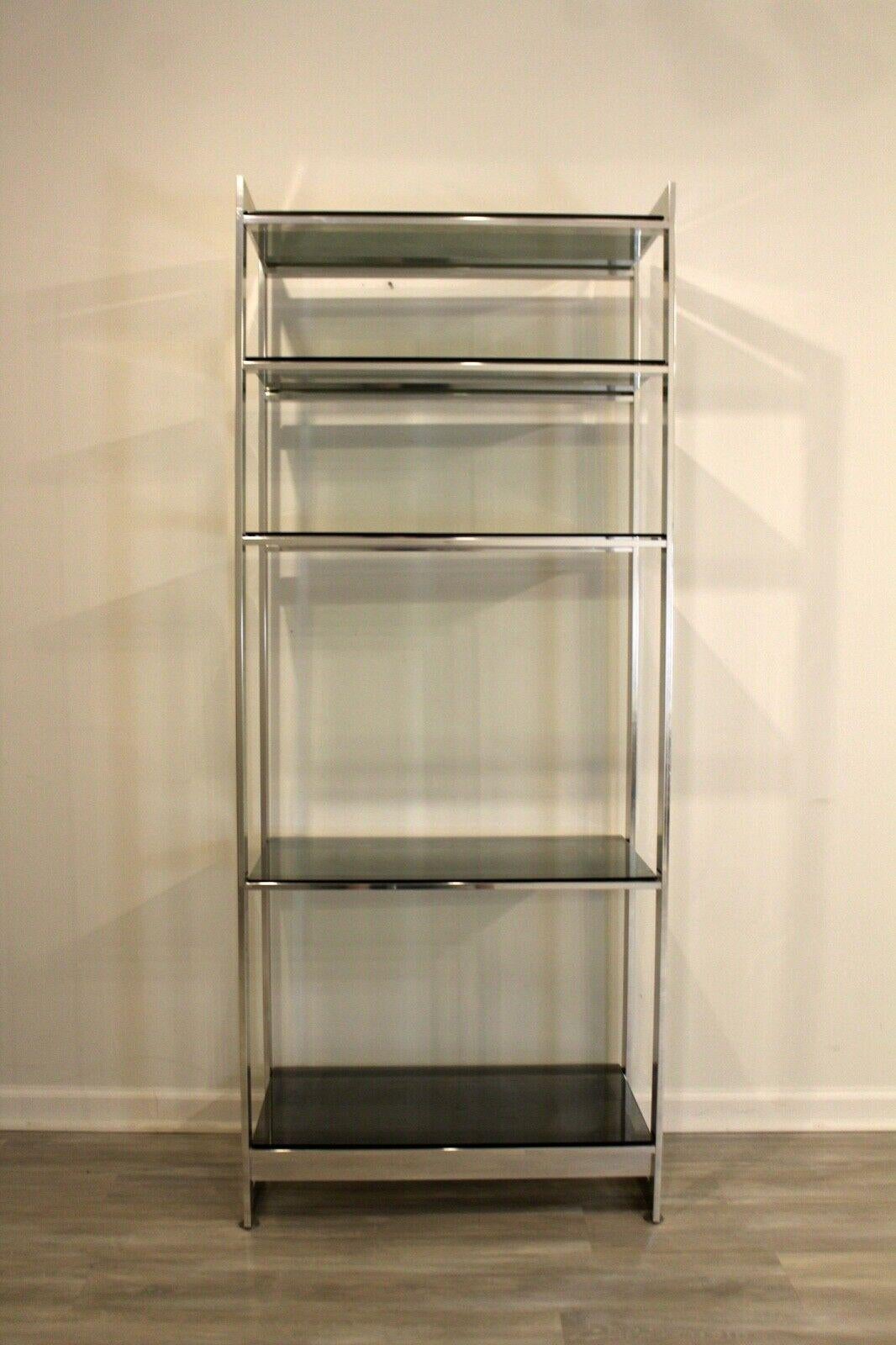 From Le Shoppe Too in Michigan comes this Mid-Century Modern with five shelves in smoked grey glass. Polished chrome framing brings this unit together in a functional, yet beautiful storage piece. In good condition.

Dimensions: 30.5 W x 16.5 D x