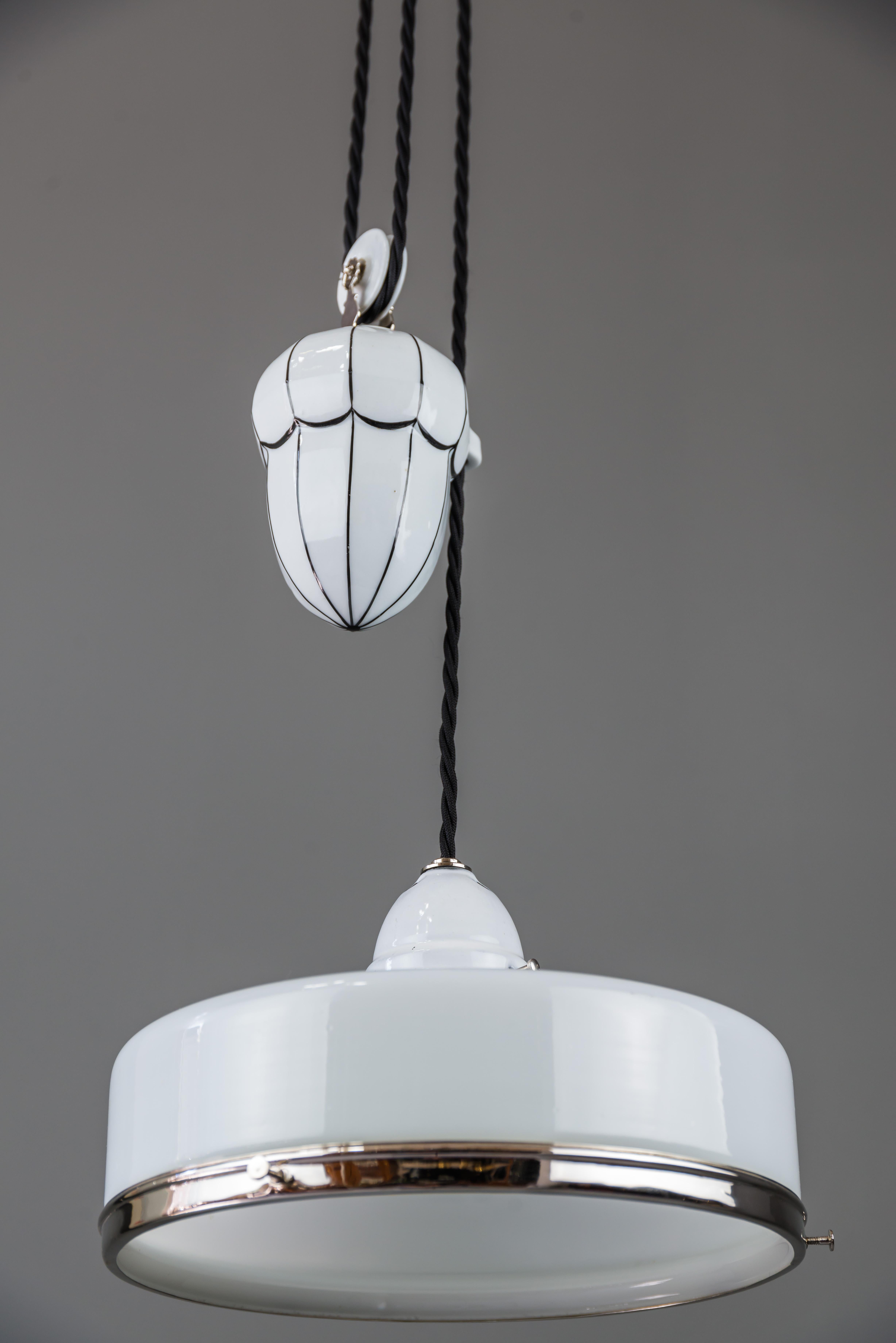 Bauhaus adjustable porcelain chandelier with original shade, circa 1920s.
Partly nickel-plated.
White porcelain with black stripes.
Normal high: 90cm extendable up to 174cm.