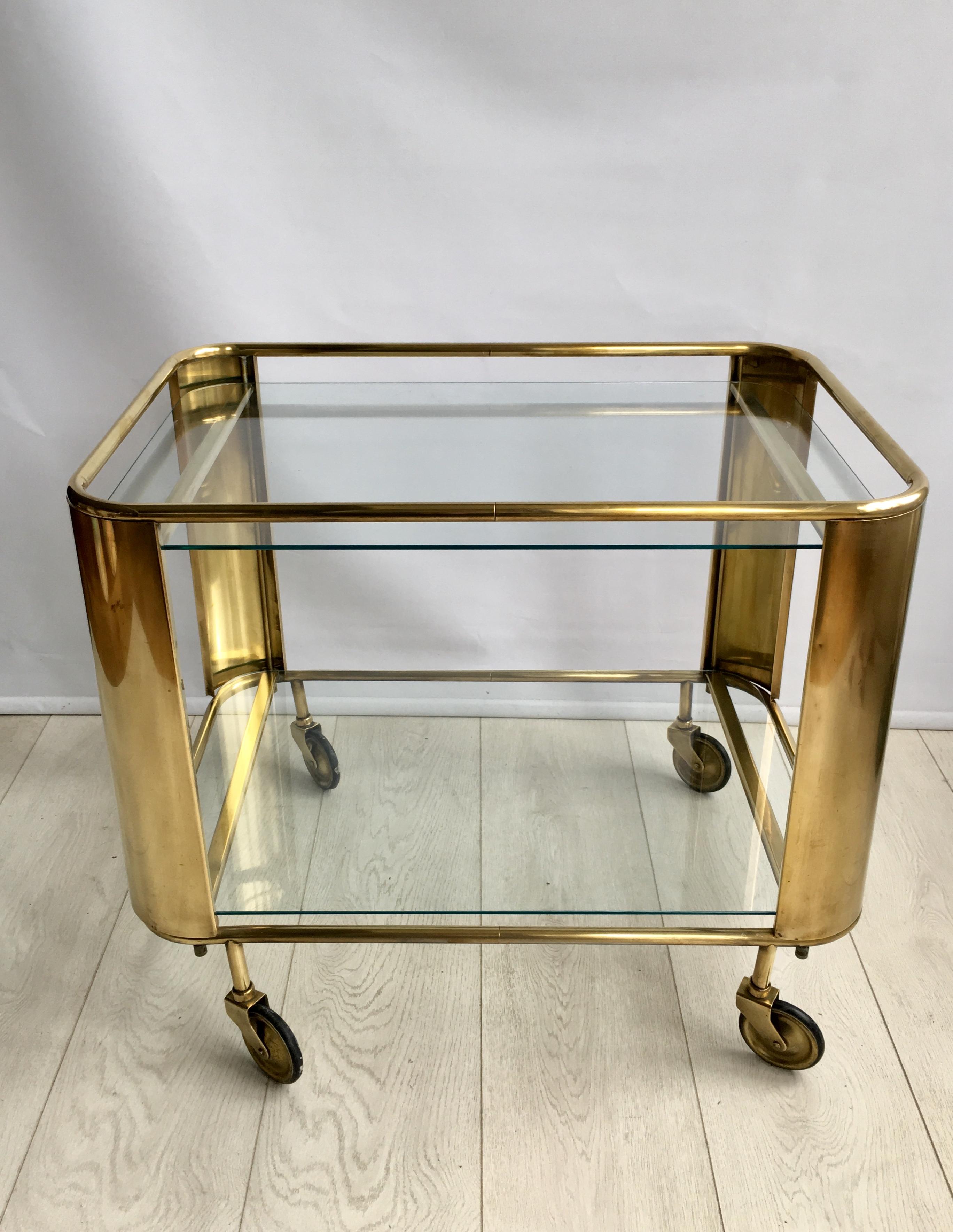 Beautifully simple in design this vintage drinks trolley 

Polished brass frame with 2 clear glass shelves

Original wheels, perhaps slightly wonky as per image but still functional and the trolley is level.
