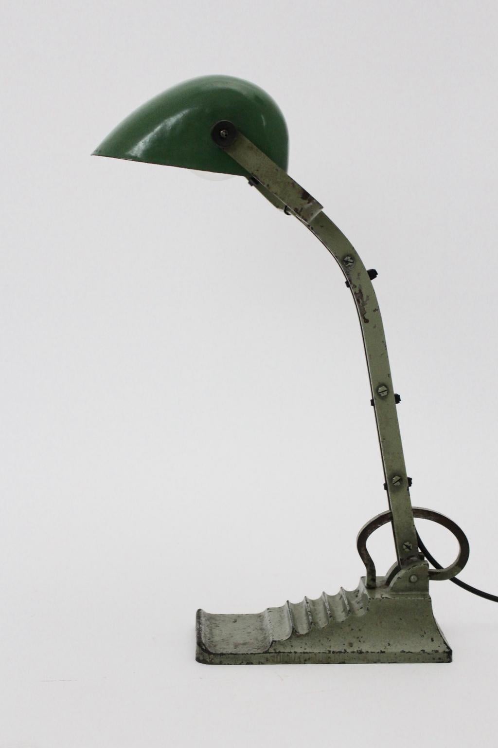 Bauhaus Art Deco table lamp or architects desk lamp from green metal adjustable from up to down, 1920s.
The green lacquered metal base shows a great patina.
The metal lamp shade is green and white enameled.
One E 27 socket
approx. measures:
Width 26