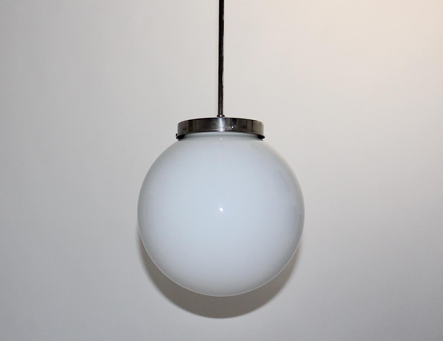 Bauhaus Art Deco vintage pendant hanging lamp chandelier with a nickel-plated metal base and an opal glass shade 1930s, Germany.
This amazing Bauhaus Art Deco vintage handing lamp is composed of a nickel-plated metal stem and an opal glass lamp