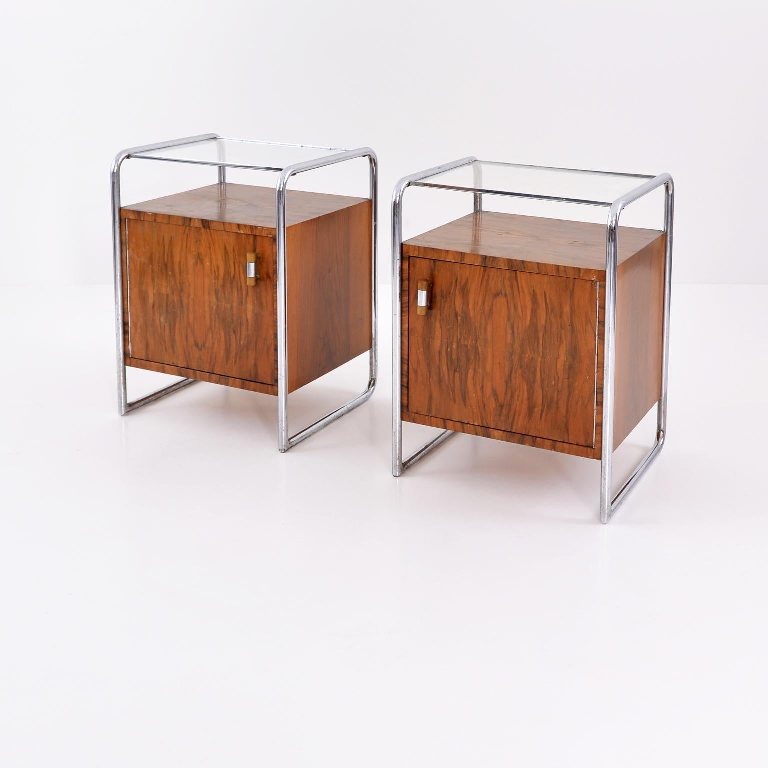 A pair of Bauhaus bedside cabinets designed by Arch. J. Fenyves in 1931-1932 and manufactured by Thonet Mundus AG, Vienna, circa 1933 as Model No. B 107. chrome-plated tubular steel, walnut veneered blockboard, glass, Bakelite. This design is in