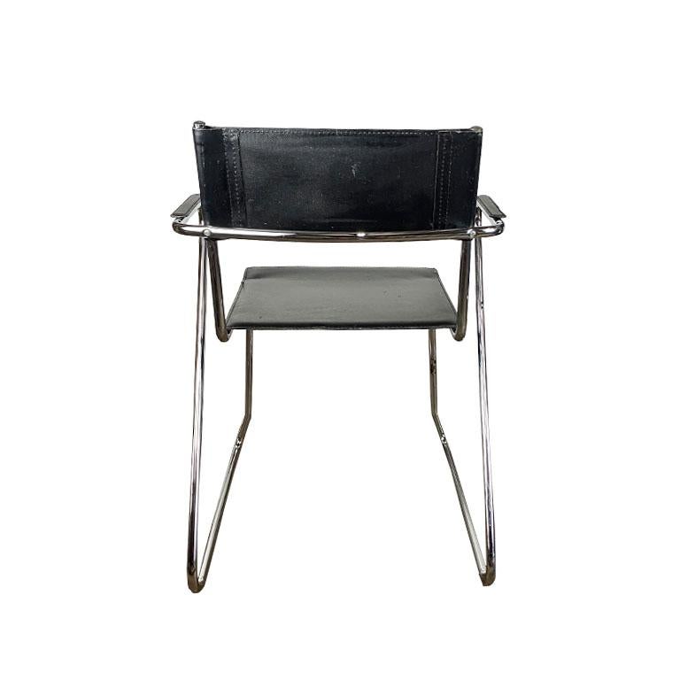 A pair of black and chrome armchairs after Marcel Breuer. This set of chairs are created from chrome with tubular frames and faux leather. They have a director chair feel. Both the back and seat are made of stretched faux leather. The arms are