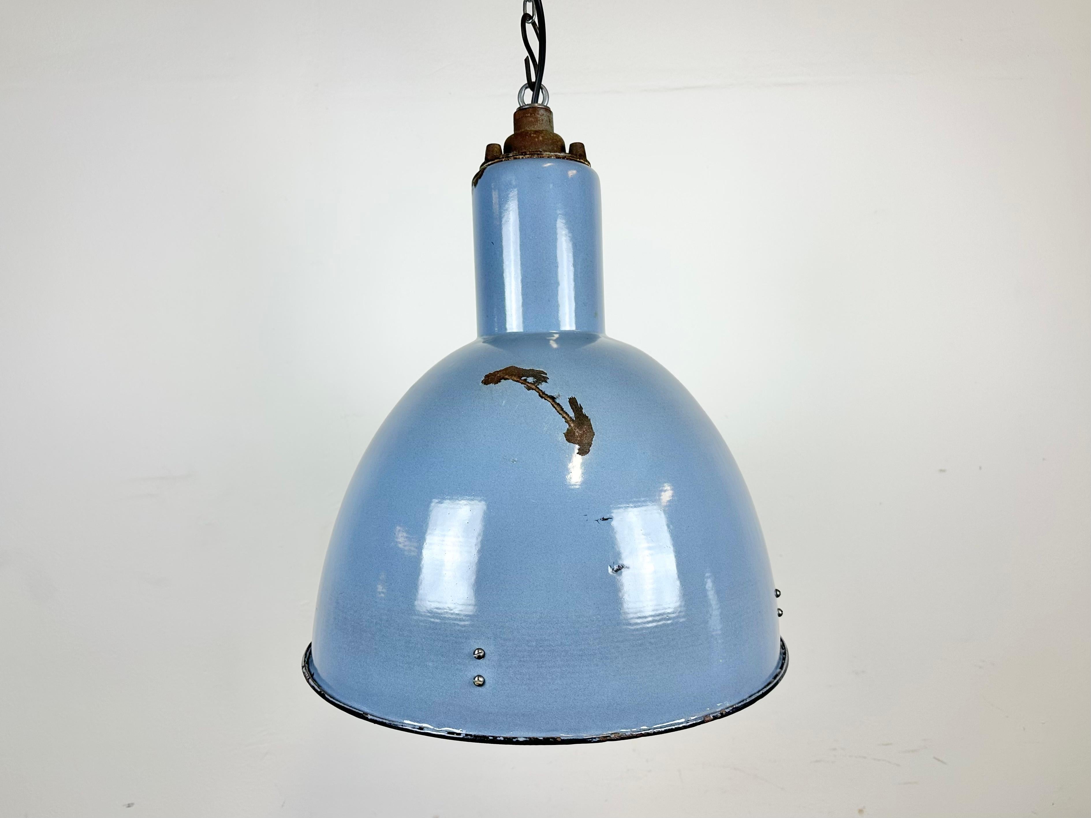 Vintage Industrial light in Bauhaus style made in former Czechoslovakia during the 1950s.It features a blue ( grey ) enamel body with white enamel interior and cast iron top. New porcelain socket requires E27/ E26 lightbulbs. New wire. The weight of