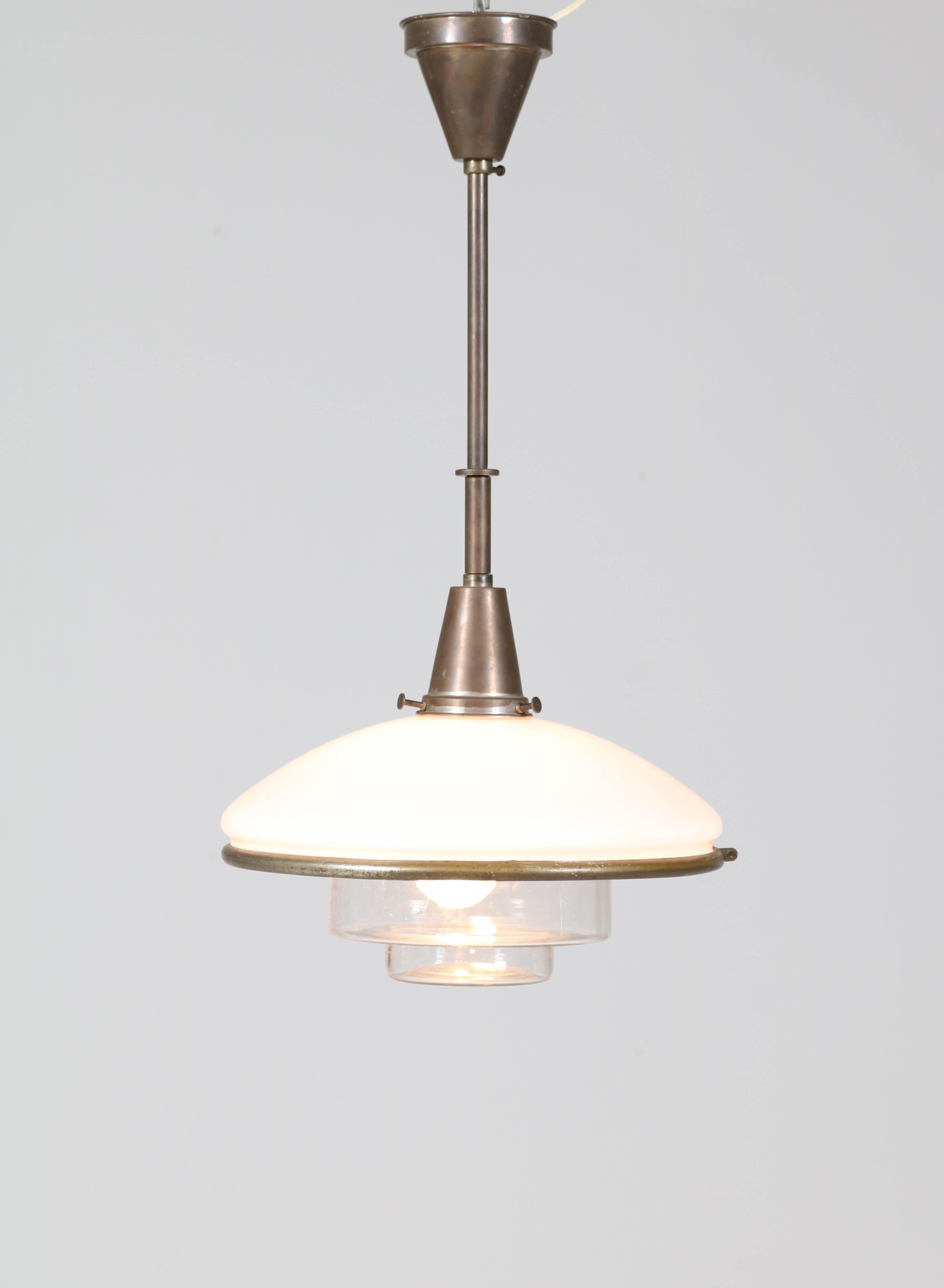 Wunderschöne Bauhaus-Pendelleuchte. 
Entwurf von Otto Müller für Sistrah Licht GmbH. 
Auffälliges deutsches Design aus den dreißiger Jahren. 
Hängeleuchte aus Messing mit zwei originalen Glasschirmen. 
In gutem Originalzustand mit geringen alters-