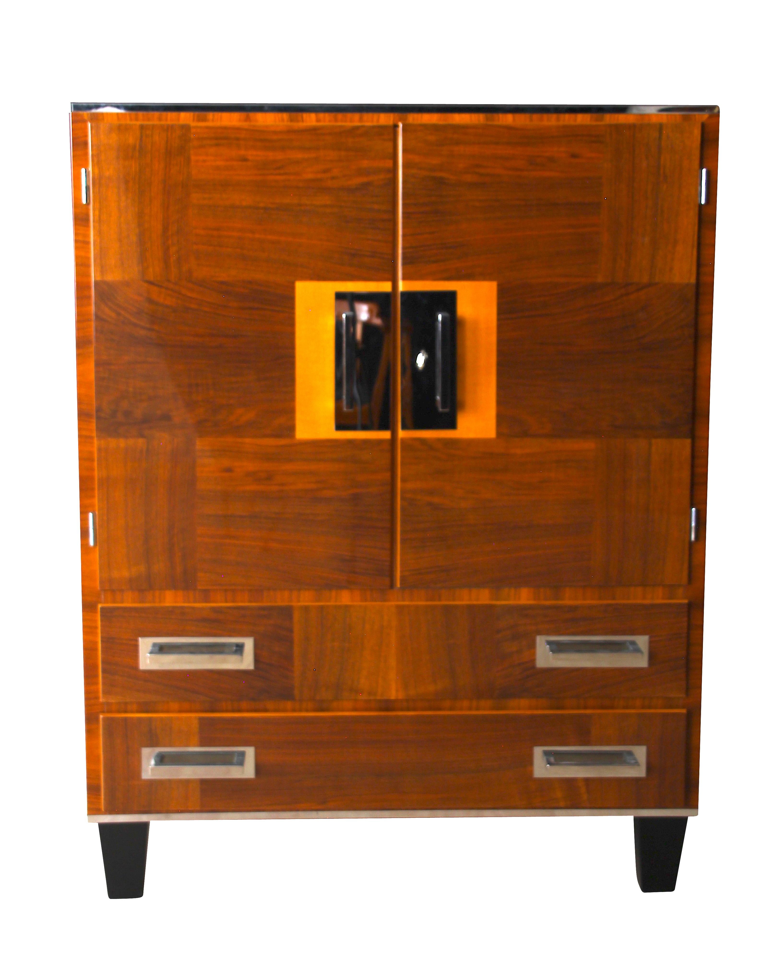 Strict / Spartan German Bauhaus cabinet from the 1930s with very functional interior.

Beautiful veneer work with vertically and horizontally in walnut. 
Wonderfully lacquered with 2k-PUR Clear Lacquer and high-gloss polished. 

Frontside has two