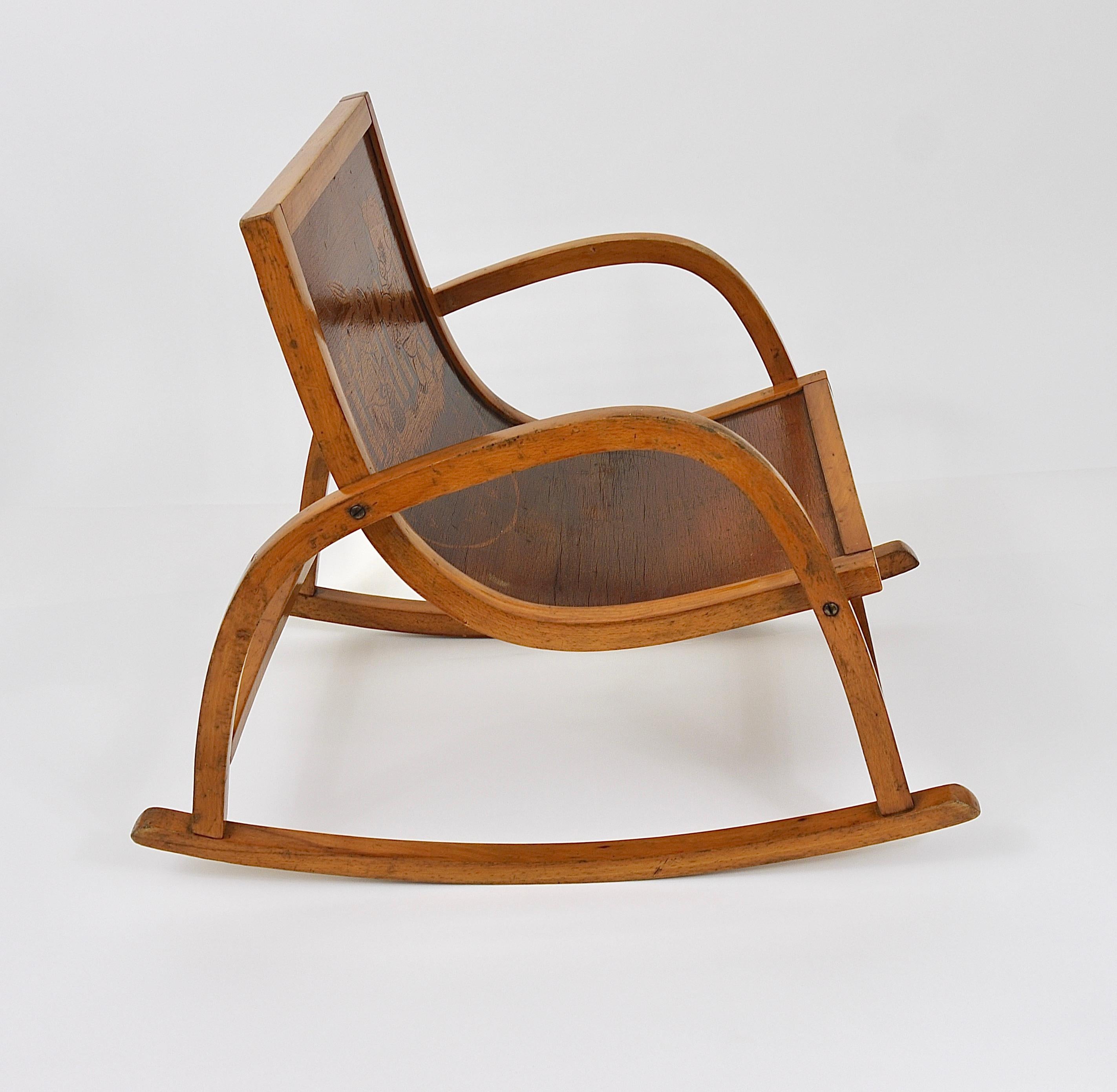 A beautiful and cute little Bauhaus rocking chair for children. Made in Germany in the 1950s, in the style of Hans Brockhage und Erwin Andrä. Made of bentwood with a charming fairy tale motif on its backrest. In very good condition with nice patina.