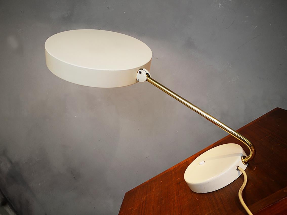 Adjustable Kaiser iDell desk lamp with an enameled shade connected by a curved brass stem and a enameled base. The lamp has the ball joint patented by Kaiser Leuchten, with which the lampshade can be individually adjusted. This allows the screen to