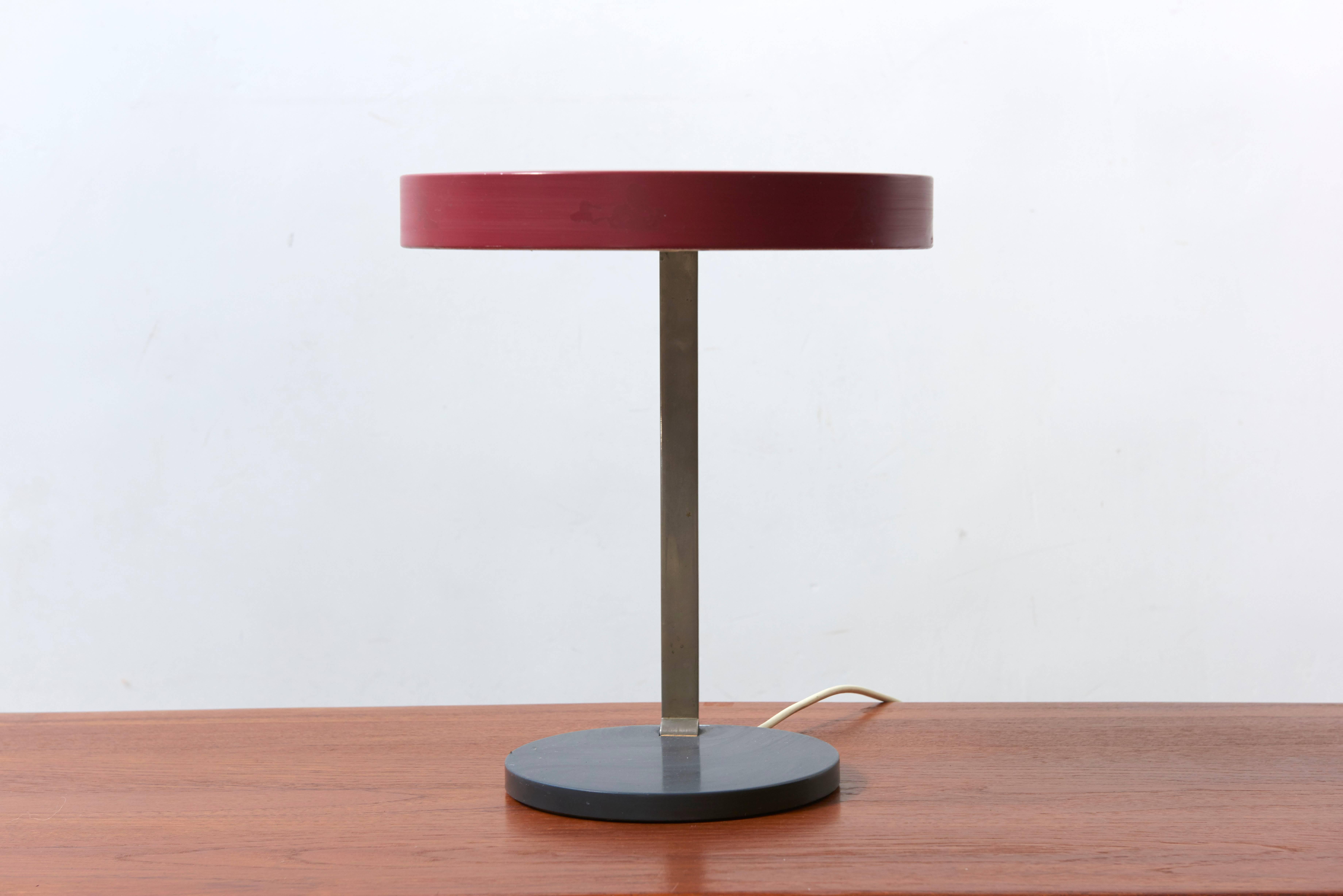 Adjustable desk lamp with an enameled red shade connected by a nickel stem and grey enameled base, by Bauhaus designer Christian Dell. Labeled by Kaiser Leuchten.

The most famous work of Bauhaus designer Christian Dell, the Kaiser Idell lighting