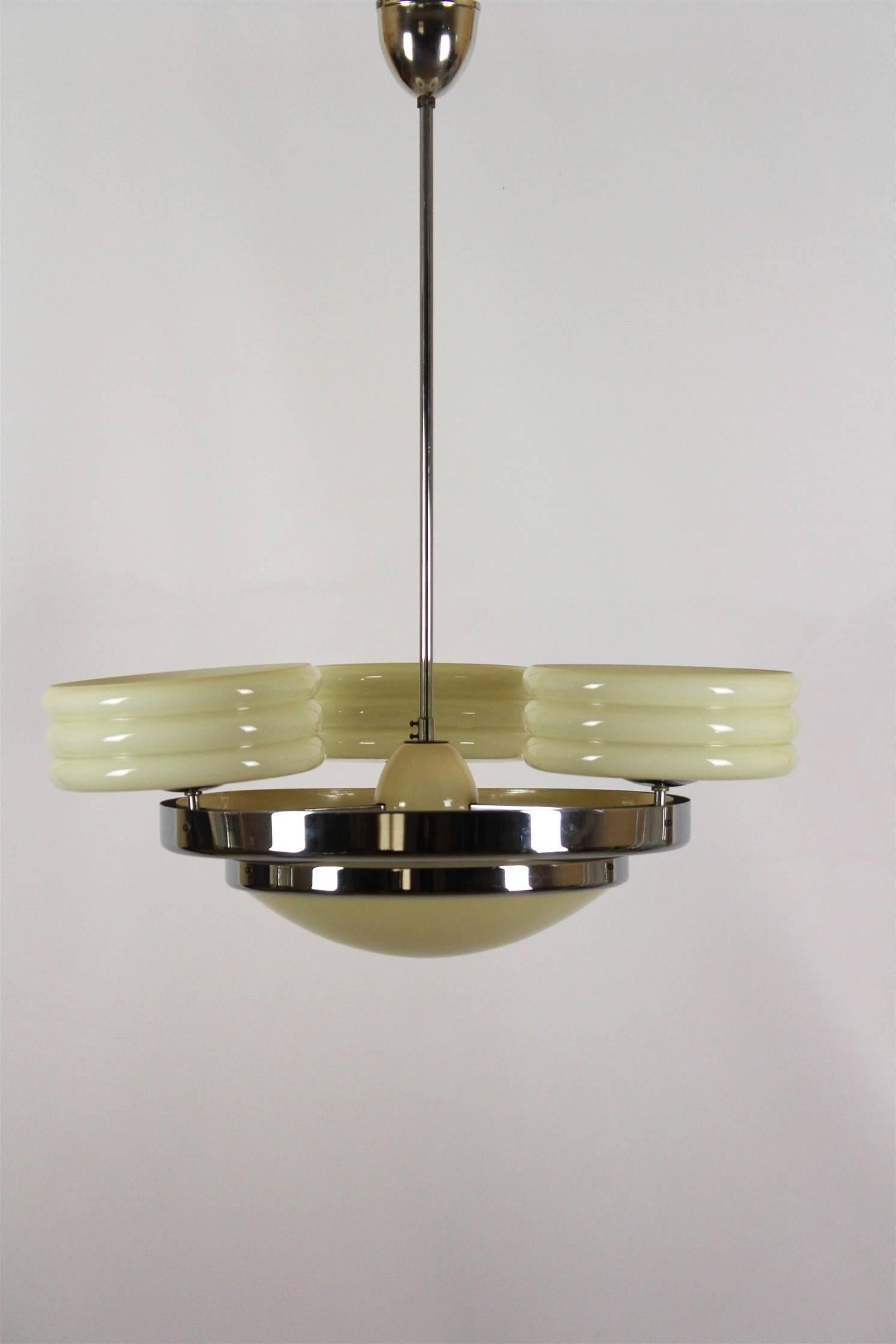 This Art Deco chandelier was manufactured by Zukov in the 1930s. The light is made of chrome-plated steel and opaline glass and is in original condition.