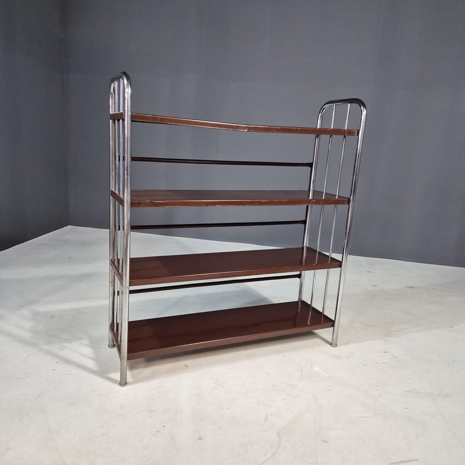 Questa elegante étagère in stile Bauhaus risale agli anni '30 ed è stata realizzata in Europa. Con la sua struttura minimalista in acciaio cromato piegato e scaffali in lamiera, mette in mostra le linee pulite e il funzionalismo tipico del