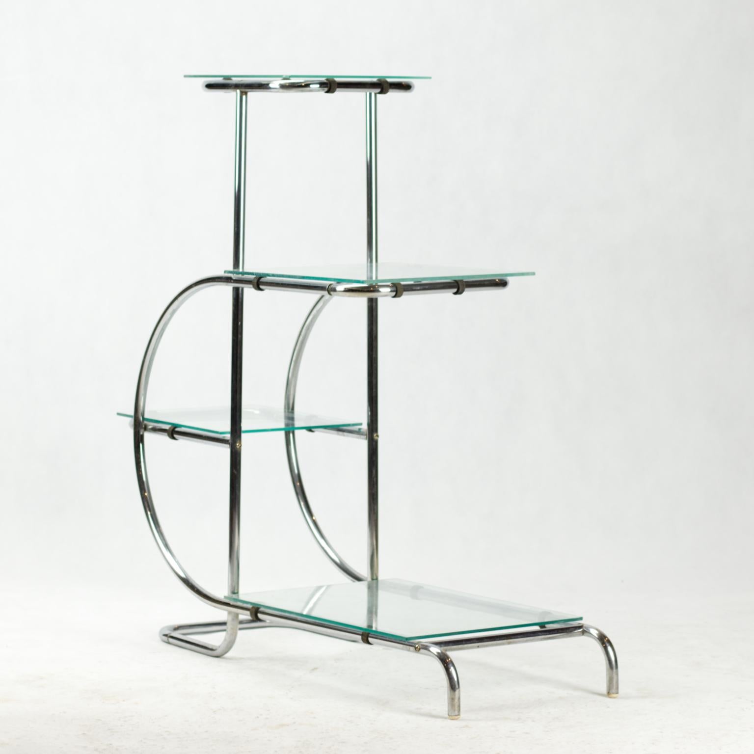 Chrome-plated tubular steel étagère designed by Emile Guyot and made in the 1930s with glass shelves. Chrome plating is in original condition.