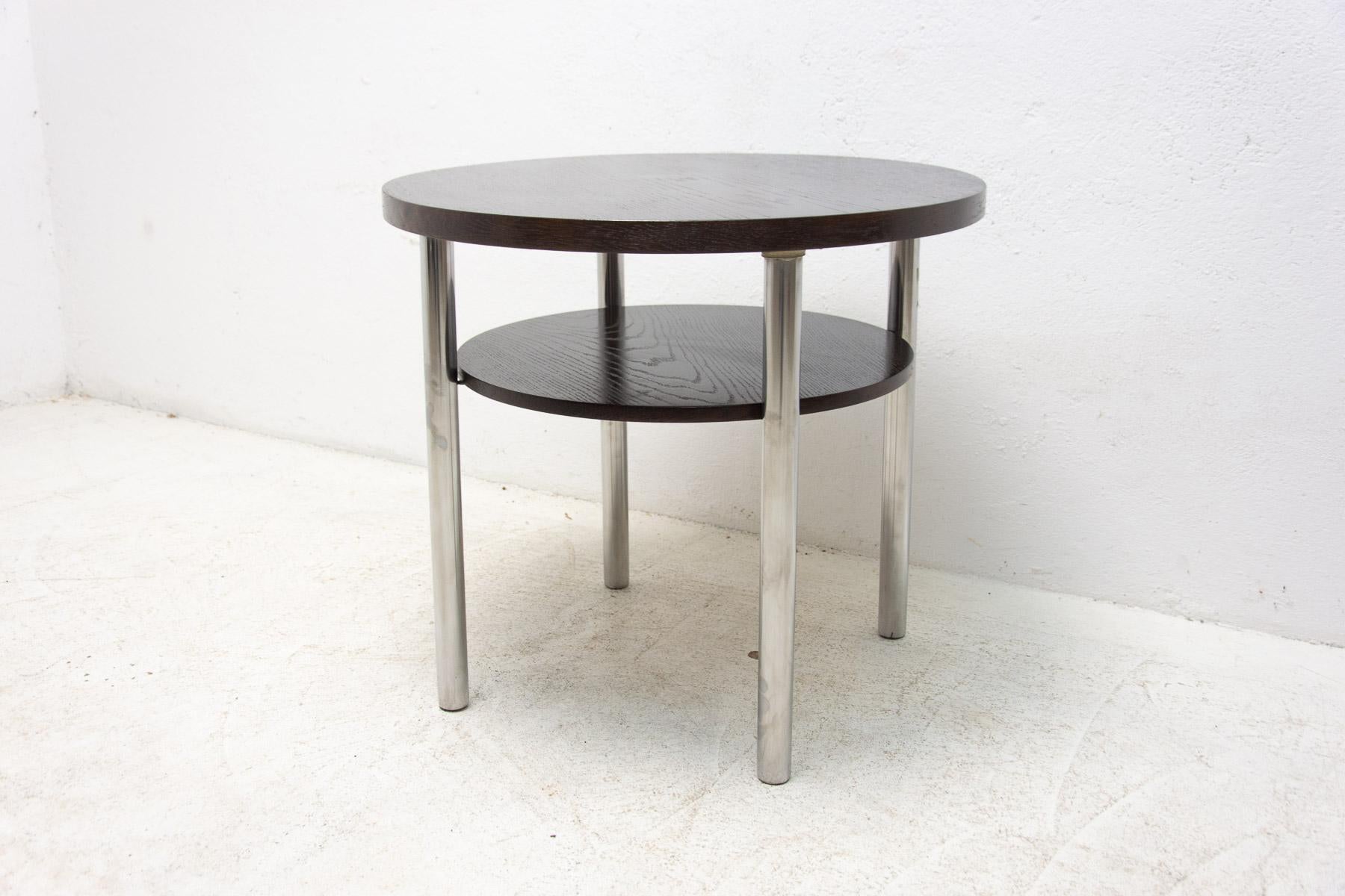 This coffee table was designed by Robert Slezák in the 1930´s and made in the former Czechoslovakia in the 1950s by the famous company Kovona. The table features a chrome-plated metal base and dark stained oak wood plates. Chrome structure is in
