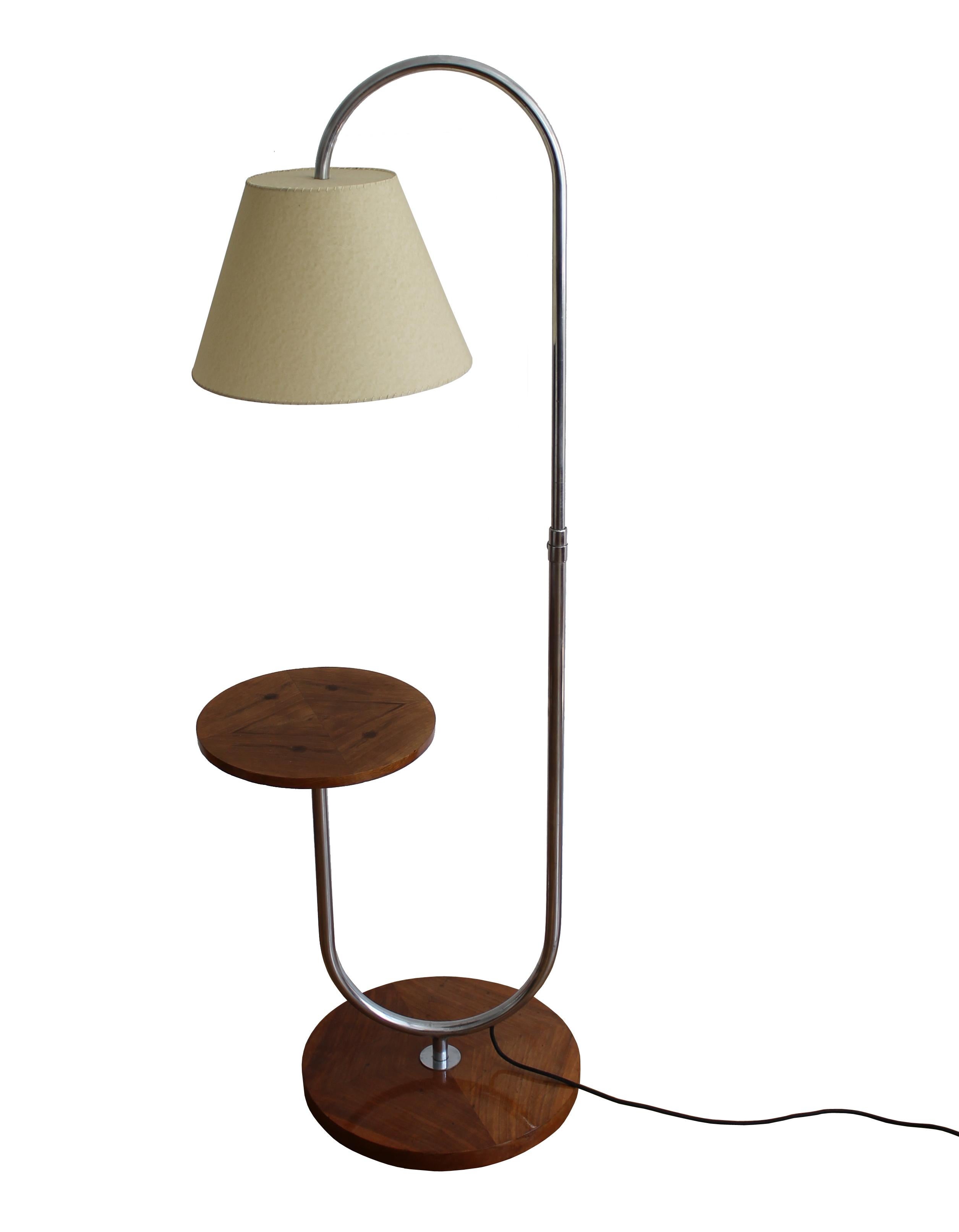 This Modernist floor lamp was designed by Robert Slezak and produced by The Slezak Company in the 1930s Czechoslovakia. This piece has got an elegant shape with a beautiful combination of walnut veneer and chromed steel. It is a perfect companion