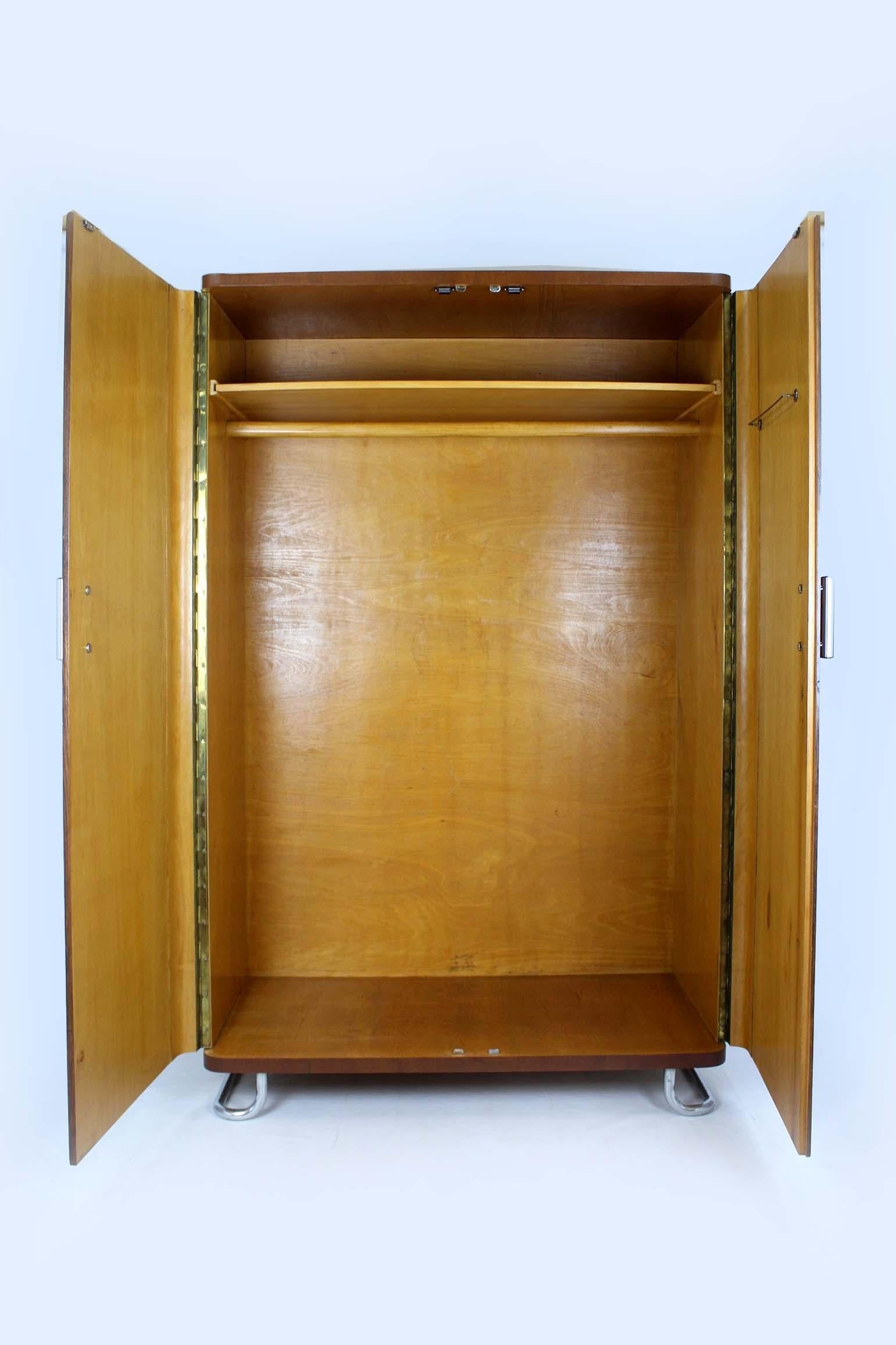 Questo armadio in stile Bauhaus è stato progettato da Hynek Gottwald e prodotto in Cecoslovacchia negli anni Quaranta. Presenta due ante, un appendiabiti interno e un ripiano. L'armadio poggia su piedini cromati ed è dotato di maniglie a cilindro