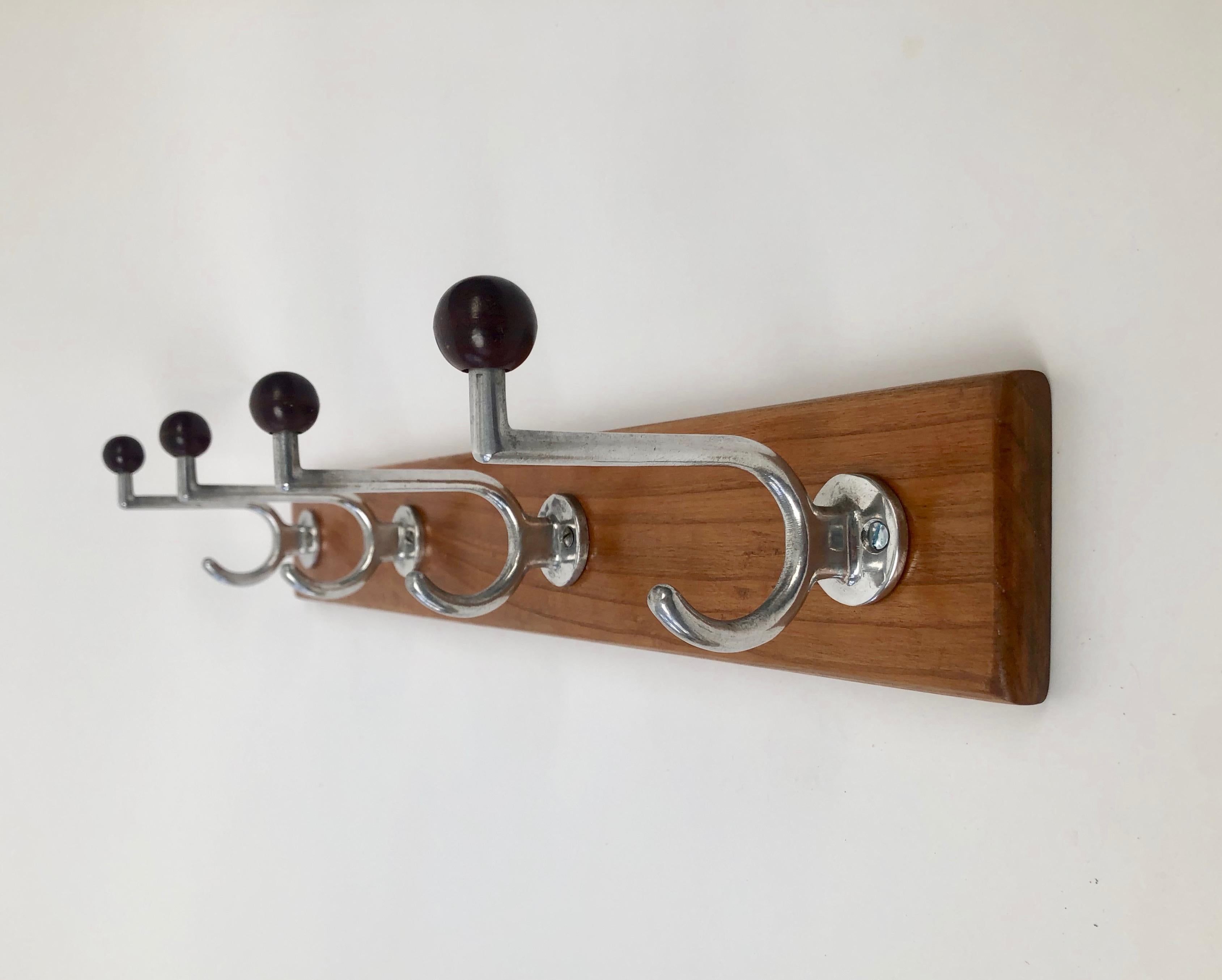 Ein schöner Satz von vier Bauhaus Kleiderhaken aus Aluminium mit Bakelitkugeln in Brauntönen...
Alle vier Haken sind an der originalen Rückwand aus Kirschholz befestigt.
Das Holz war ursprünglich mit Schellack versiegelt und ist aufgefrischt worden.
