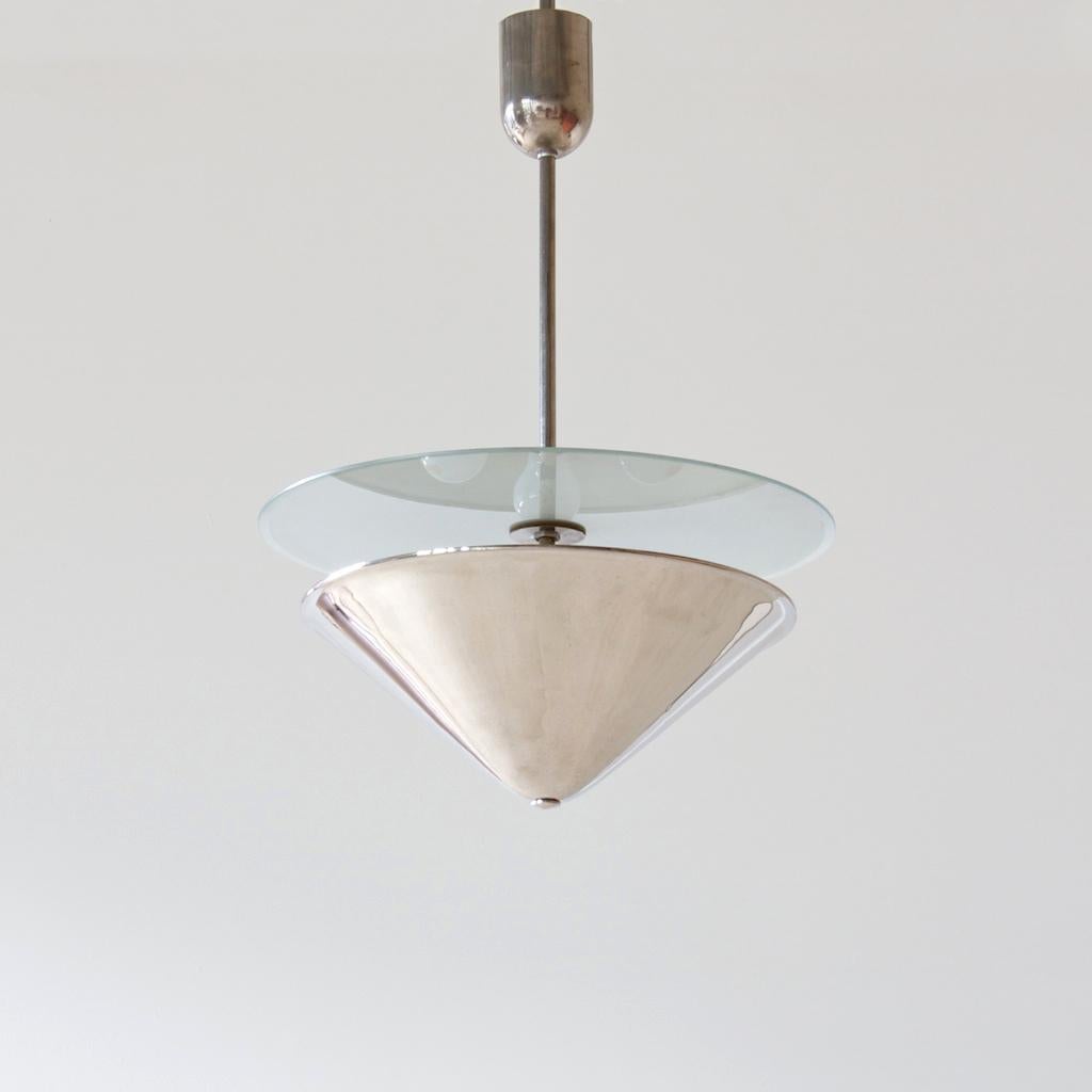 The conical lampshade directs the light towards the ceiling and generates a uniform indirect light. The beautifully built lamp has a light, elegant presence in the room in a reduced, rational design of the 1930s.
