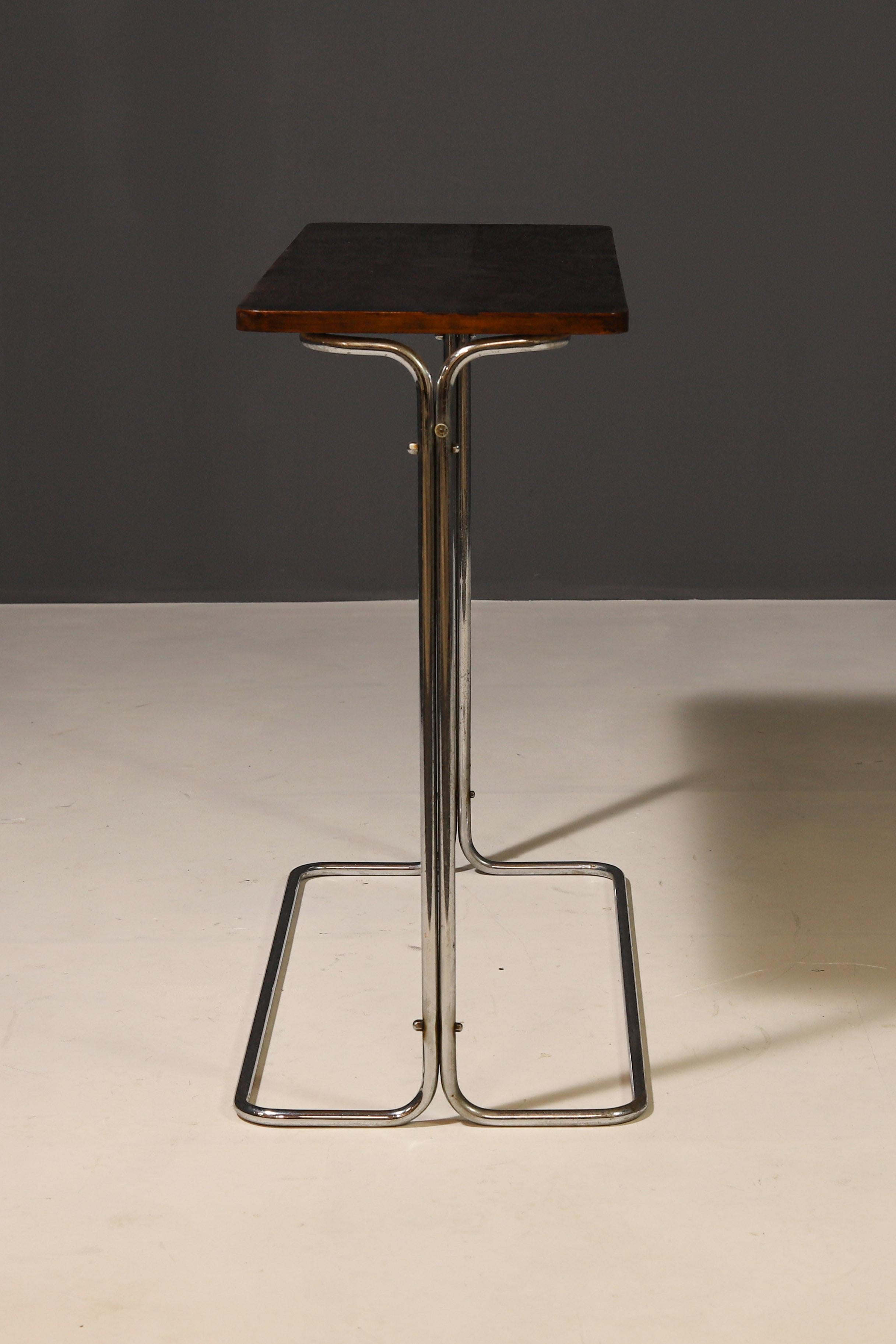 This Bauhaus Console Table was designed by Robert Slezák and made in the 1930's in the former Czechoslovakia.  It combines timeless design with functionality. The wooden top provides a fresh look, while the original chrome accents emphasize its