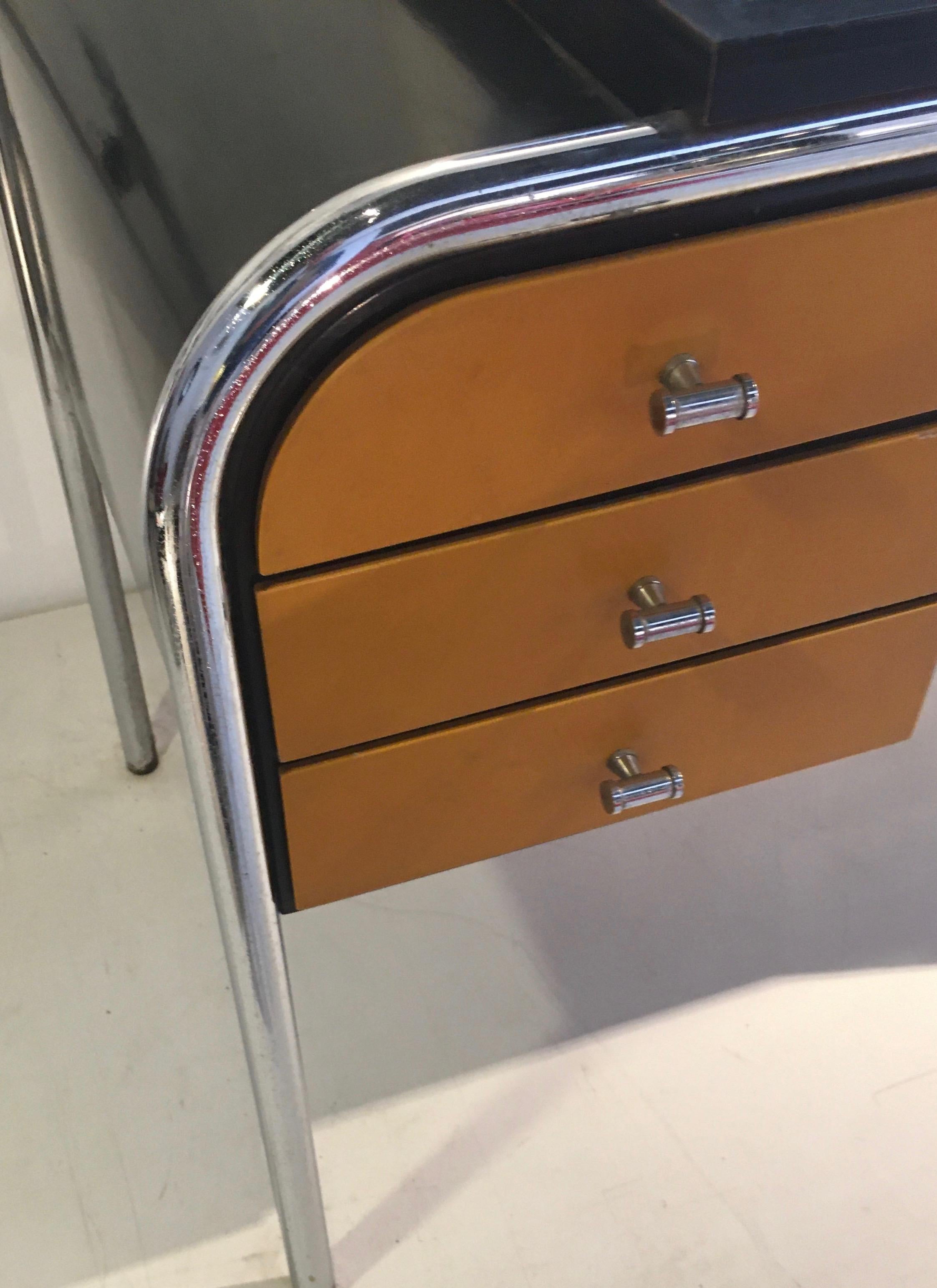 Fine dressing table, tubular chromed and black lacquered base, circular adjustable mirror and ocher lacquered drawers.
Bauhaus, Germany, circa 1930.