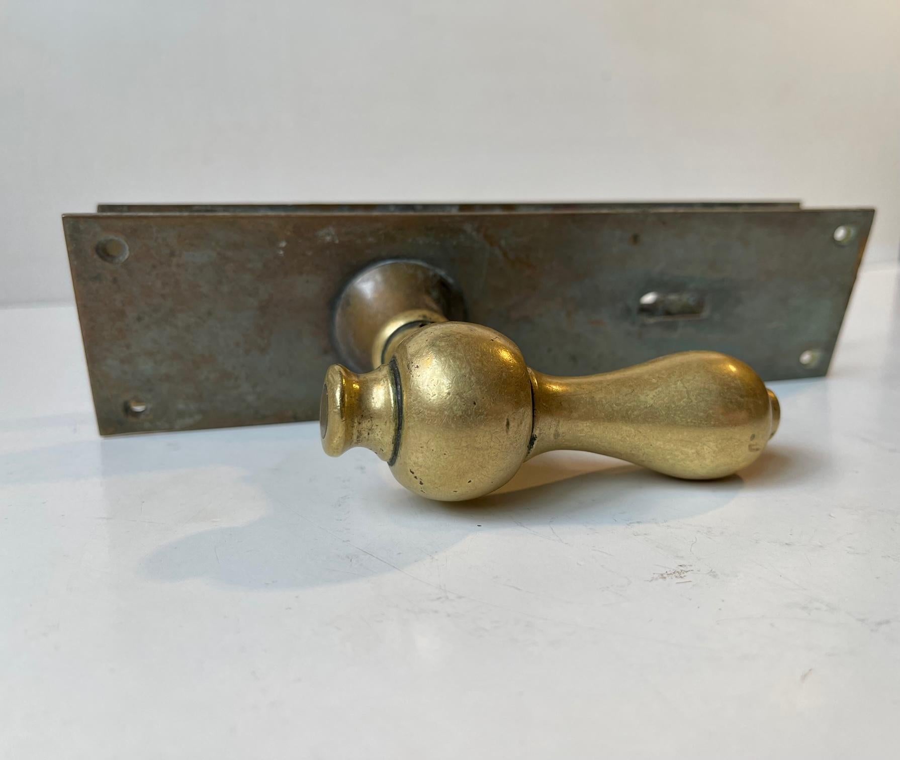 Door Handle in brass and bronze. The solid brass spindles are thick and rounded of softly due to excessive use over the years. Suitable for your office, Conservatory, Atrium etc. It was manufactured in Denmark during the 1920s or 30s. This