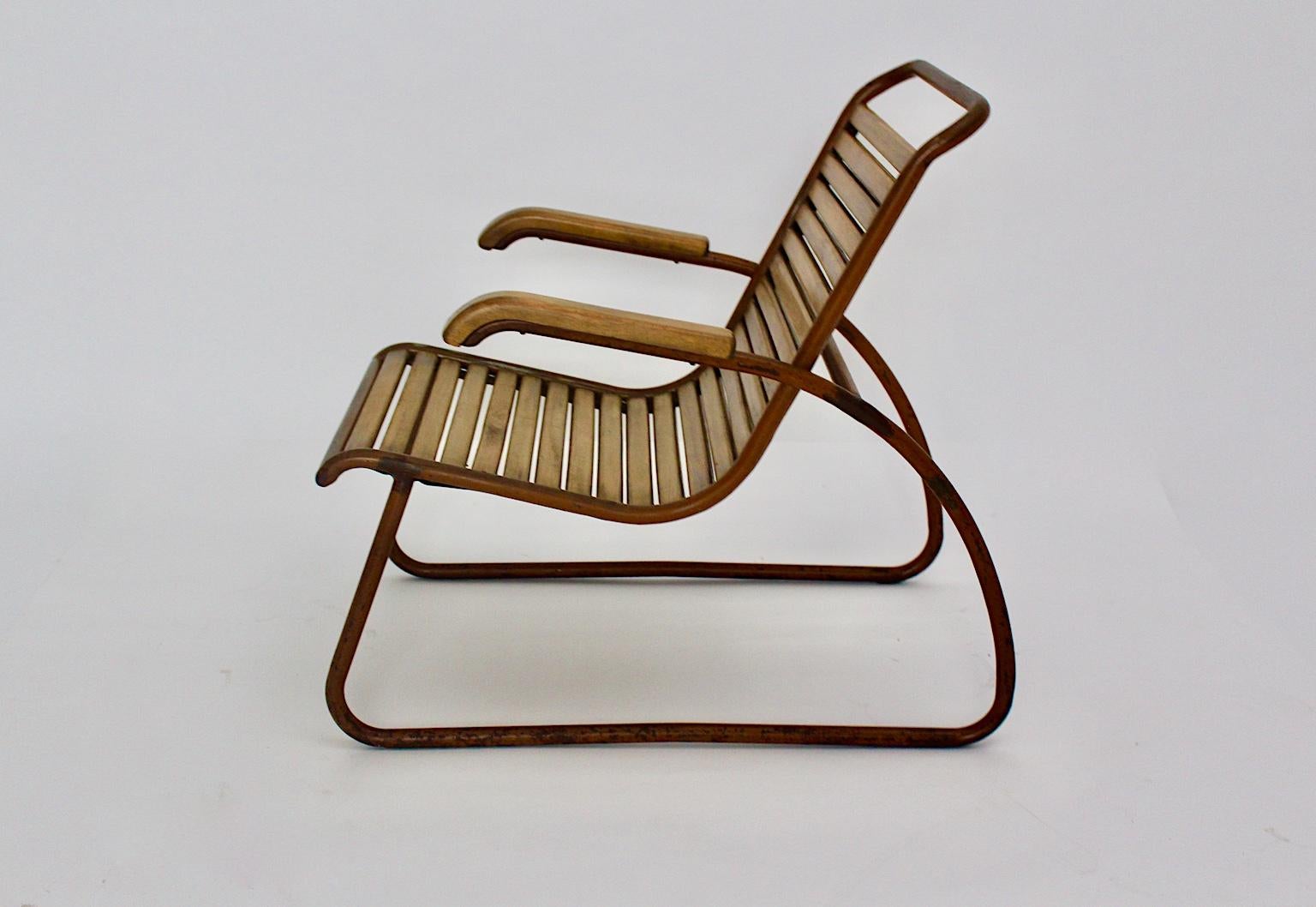 Bauhaus era vintage beech metal lounge chair or armchair, which was designed in the 1920s.
24 beechwood slats and a tube steel frame with nice color rests form this extraordinary lounge chair. A beautiful curved shape and a sleek line features the