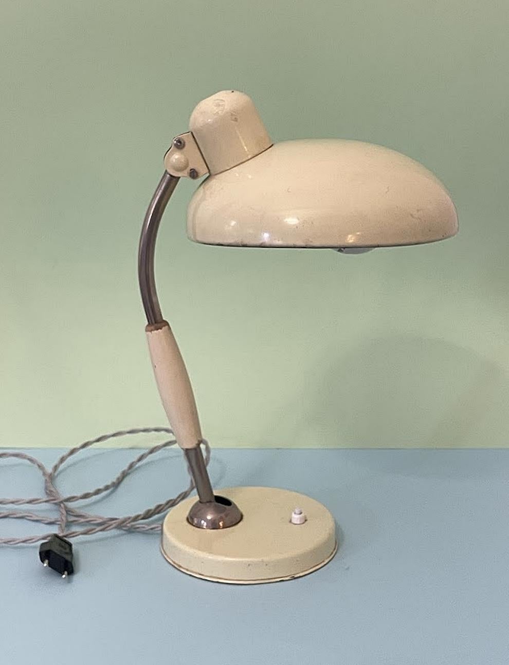 This exquisite ivory-colored table lamp, originally designed by Christian Dell in 1933 and crafted by Koranda Austria around 1950, is a true piece of history. Constructed from a blend of metal and wooden elements, the lamp boasts functional joints