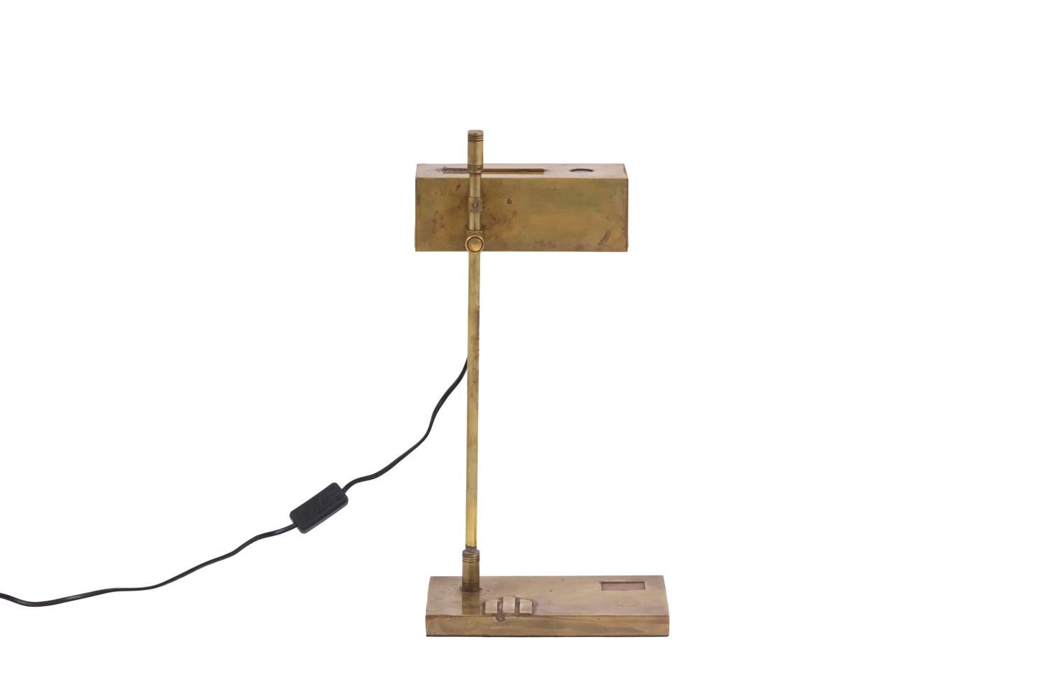 Bauhaus lamp in gilt brass standing on a rectangular base with applied motif of three gilt brass strips and a relief copper rectangle.
Shaft composed of a stick with cylindrical ends with chiselled rings.
Rectangular extendable lampshade in gilt