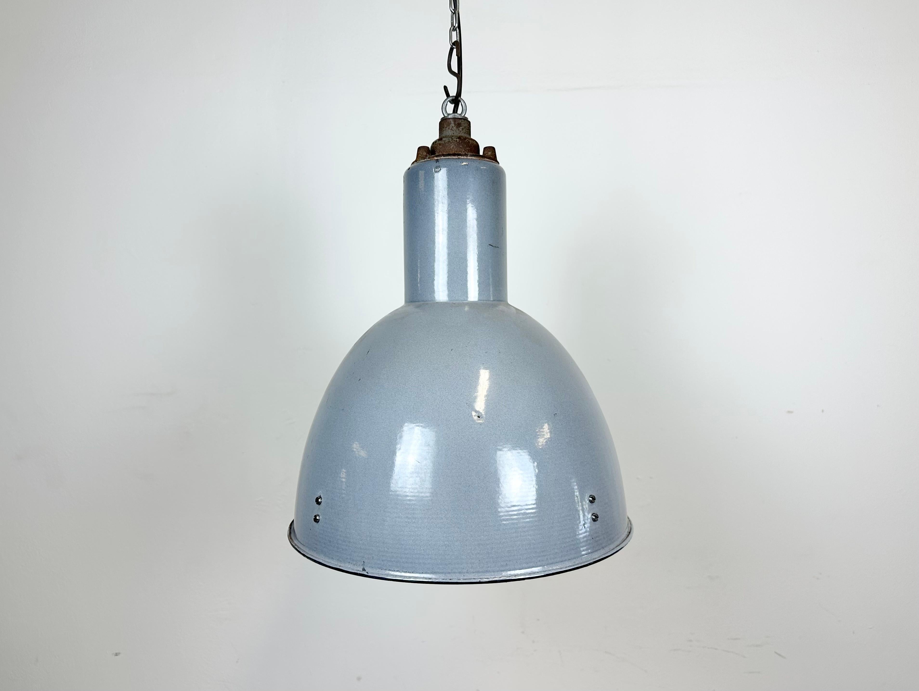 Vintage Industrial light designed in Bauhaus period made in former Czechoslovakia during the 1950s.It features a grey enamel body with white enamel interior and cast iron top. New porcelain socket requires  standard E27/E26 lightbulbs. New wire. The