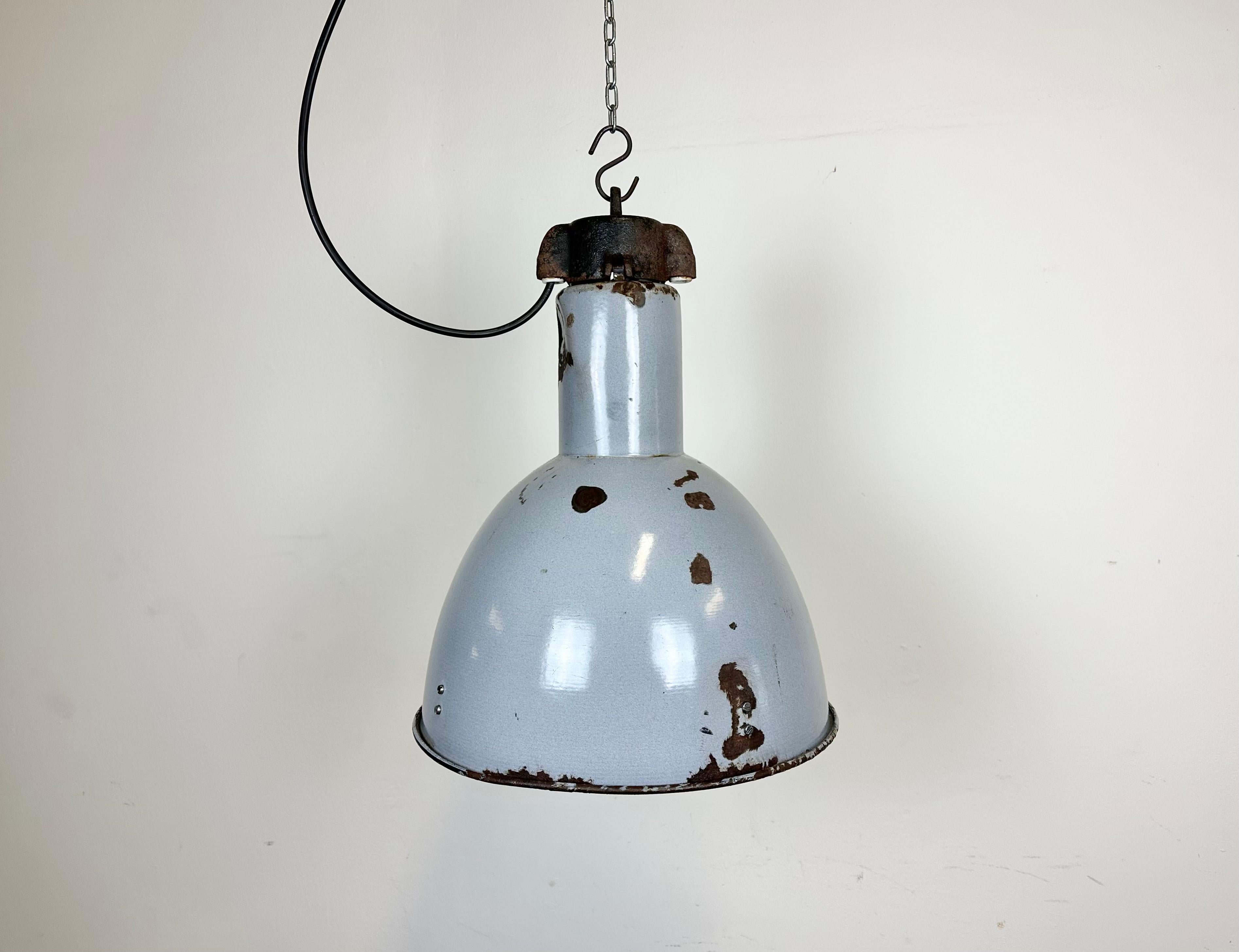 Vintage Industrial light in Bauhaus style made in former Czechoslovakia during the 1950s.It features a grey enamel body with white enamel interior and cast iron top. New porcelain socket requires E27/ E26 lightbulbs. New wire. The weight of the lamp