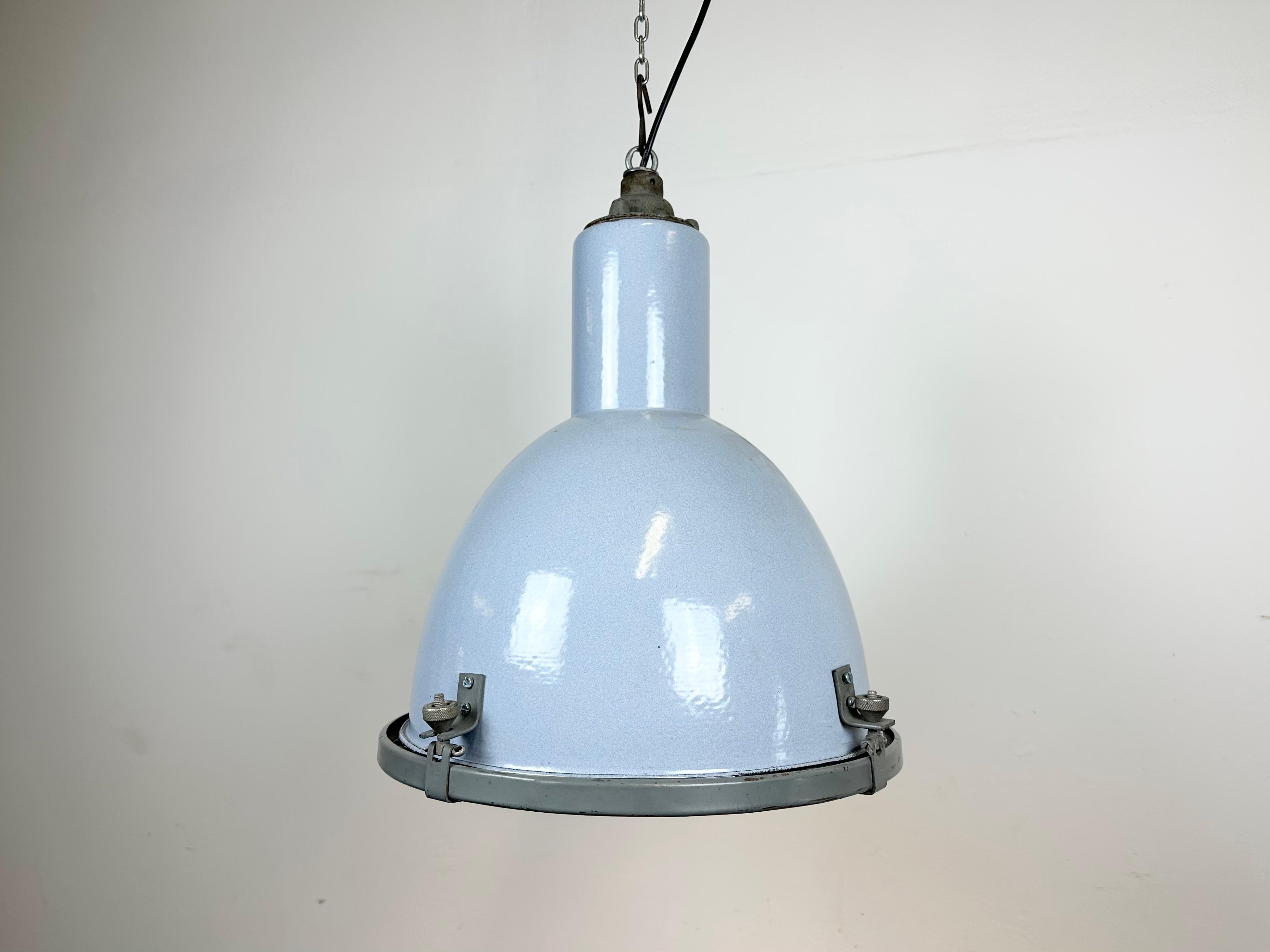 Vintage Industrial light in Bauhaus style made in former Czechoslovakia during the 1950s.It features a light grey ( light blue ) enamel body with white enamel interior, a cast iron top and clear glass cover. New porcelain socket requires E27/E26